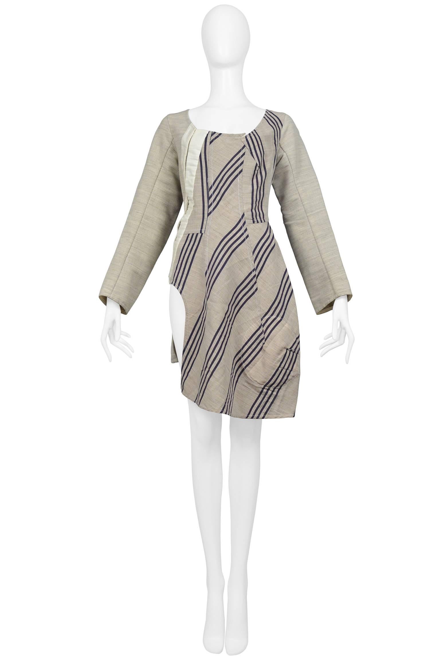 Vintage Comme des Garcons natural tone silk deconstructed tunic with navy stripe panels. The tunic top features muslin type tape with hook and eye closures at side dart. The tunic has long sleeves, an open scoop neckline, and asymmetrical hem. Shown