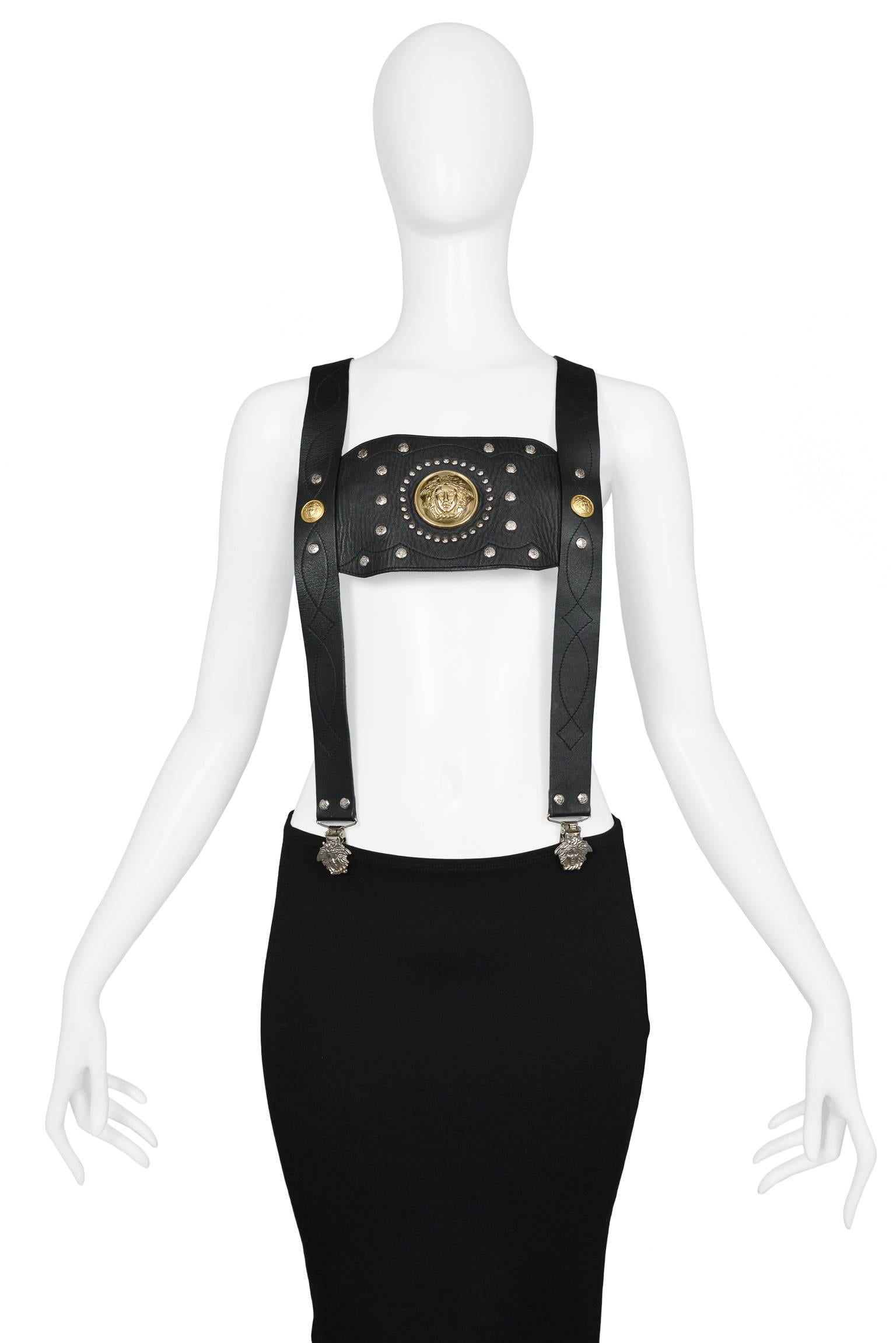 Super rare and unusual Gianni Versace black leather suspenders with gold tone studs and Medusa emblems. Suspenders feature decorative black stitching and silver Medusa clips. Back of suspenders have an elastic band with white Medusa head graphic.