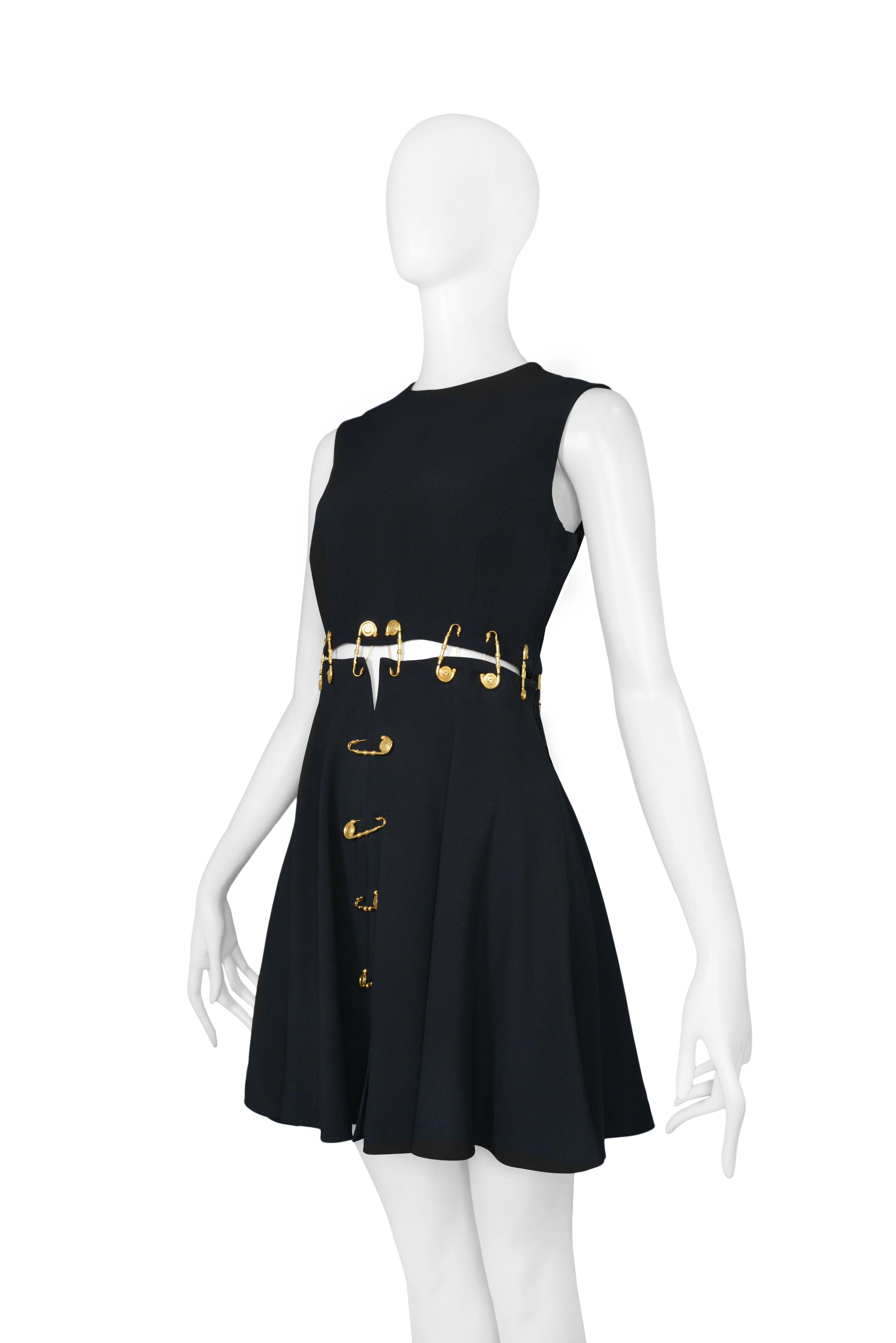 black versace dress with gold safety pins