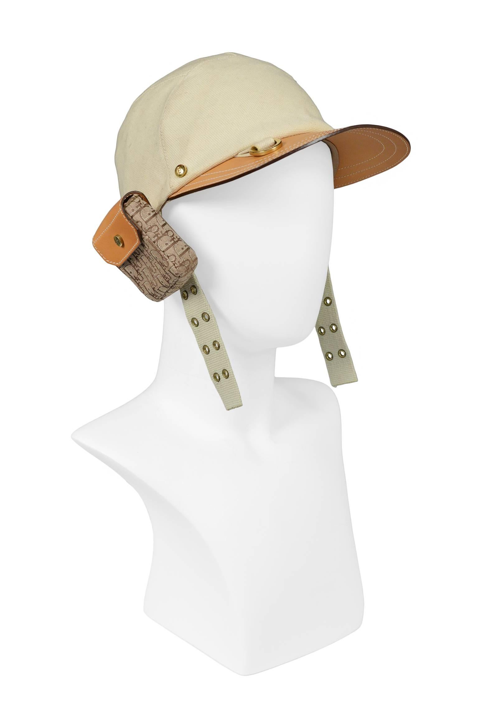 Street chic Christian Dior by John Galliano khaki canvas and tan leather cargo hat with logo pocket, gold tone hardware, and grommet utility straps. Has elastic at back for easy fit.  Hat has never been worn. Collection SS 2002.