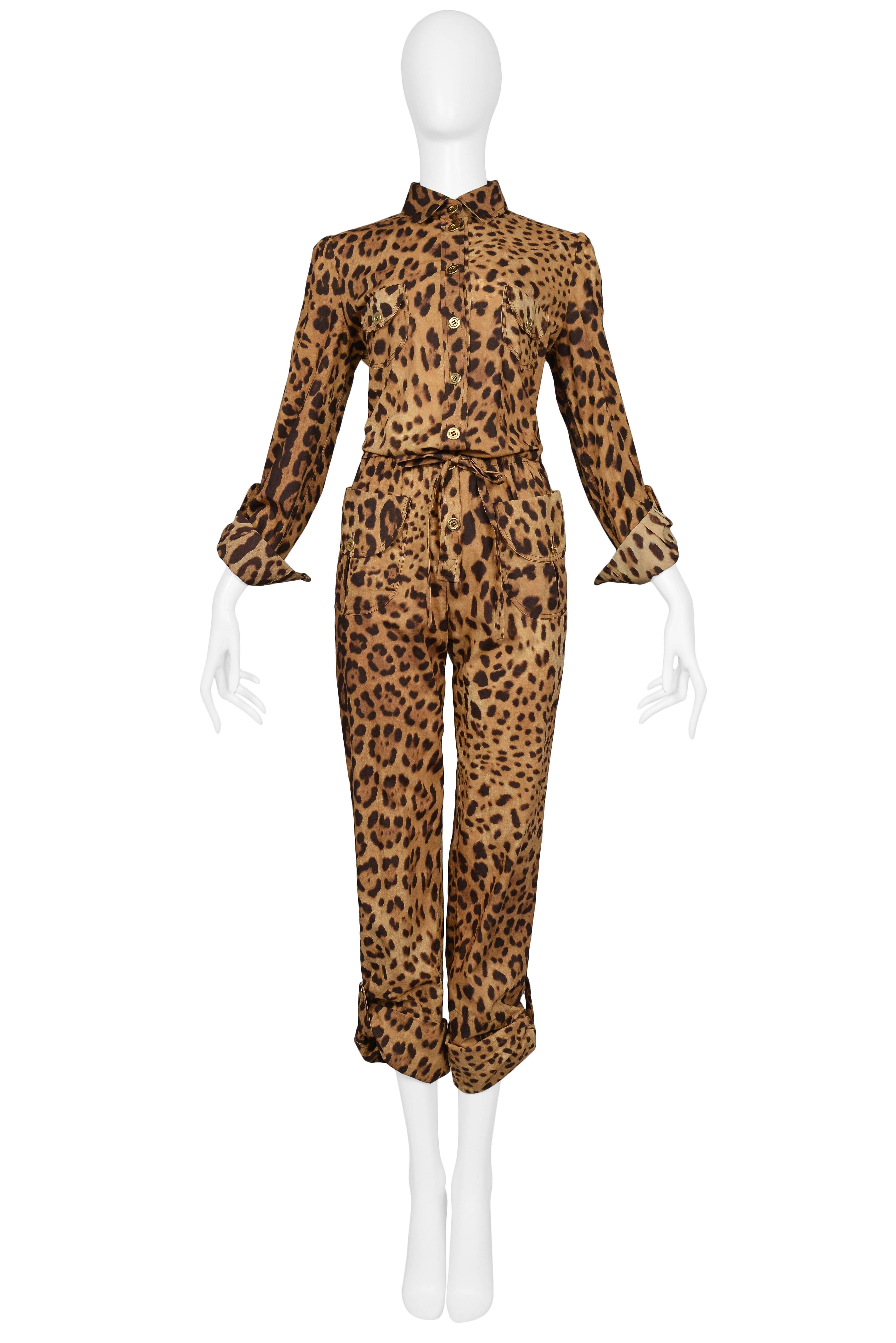 Dolce & Gabbana cotton leopard safari style belted jumpsuit with cargo pockets at front chest and hip, gold button front closure, cuff sleeves, and adjustable flap and button pant length. Slim fit and matching tie belt. 