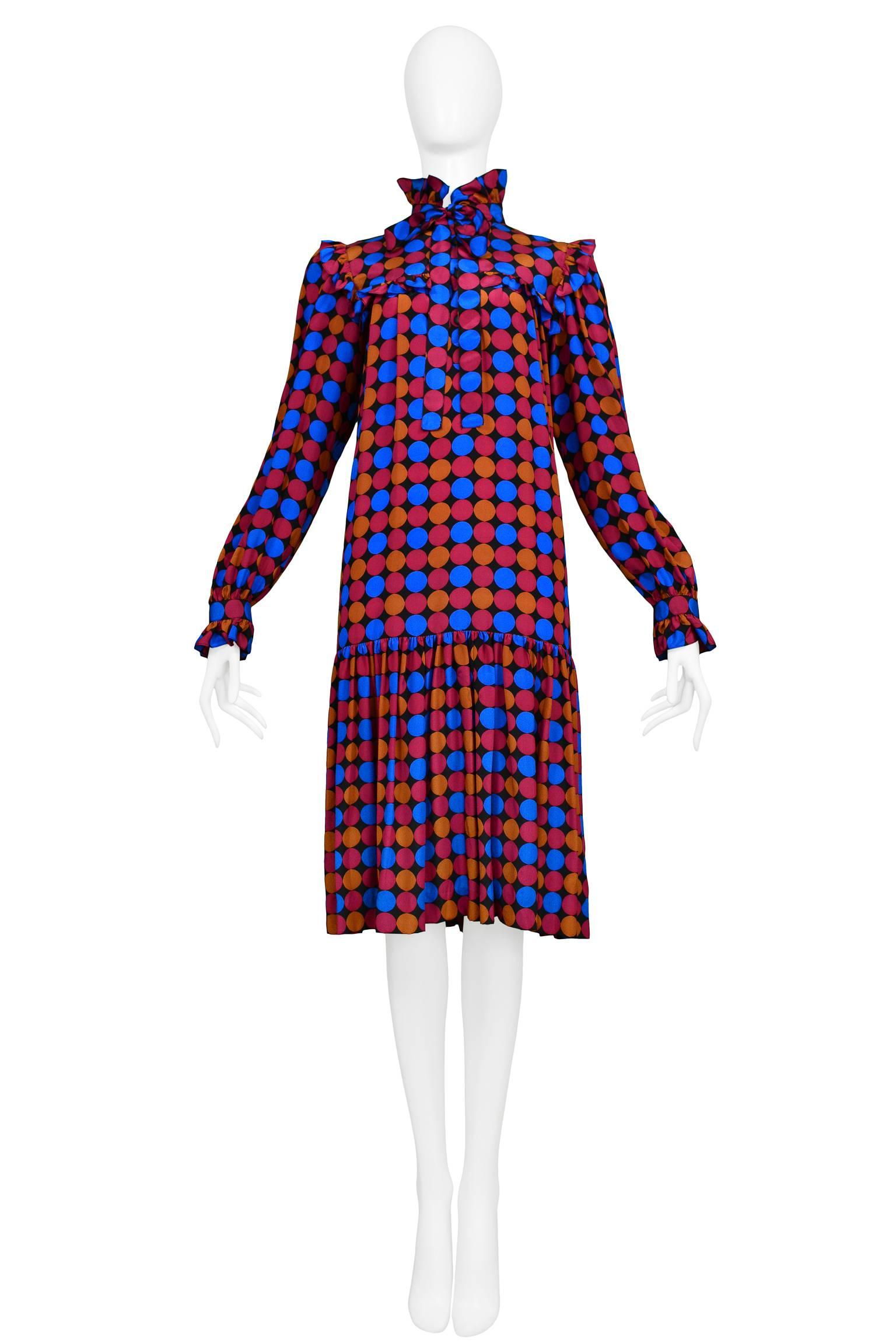 Vintage Yves Saint Laurent Day Dress featuring a drop waist, ruffle yolk and built in sash at the collar. The dress features an all over geo print of circles in magenta, blue and copper. 