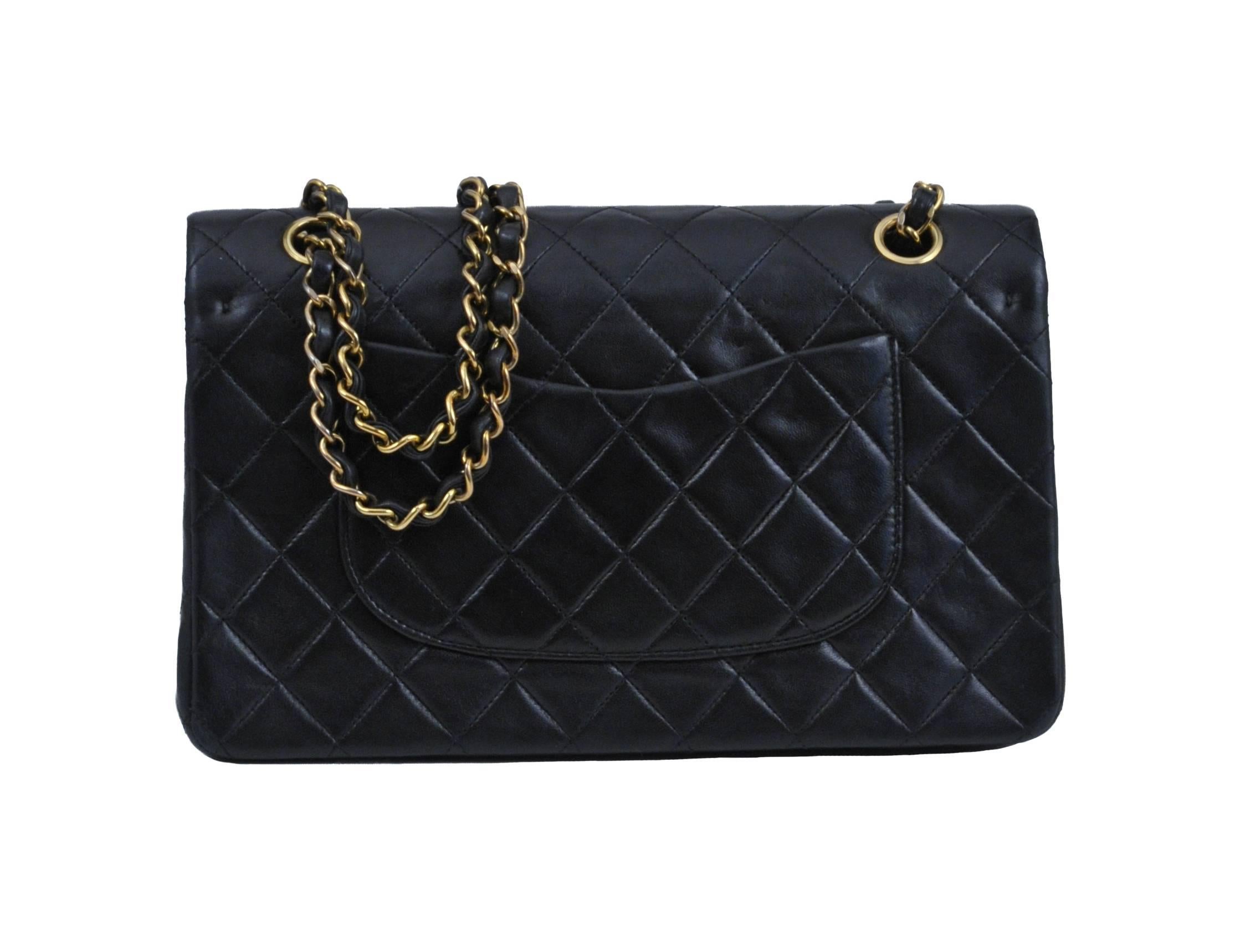 Vintage Chanel Classic 2.55 double flap bag in black quilted lambskin featuring a leather lining, iconic leather and gold tone chain woven straps, a classic patch pocket at the back, a gold tone turn-lock closure at the front and a zip pocket on the