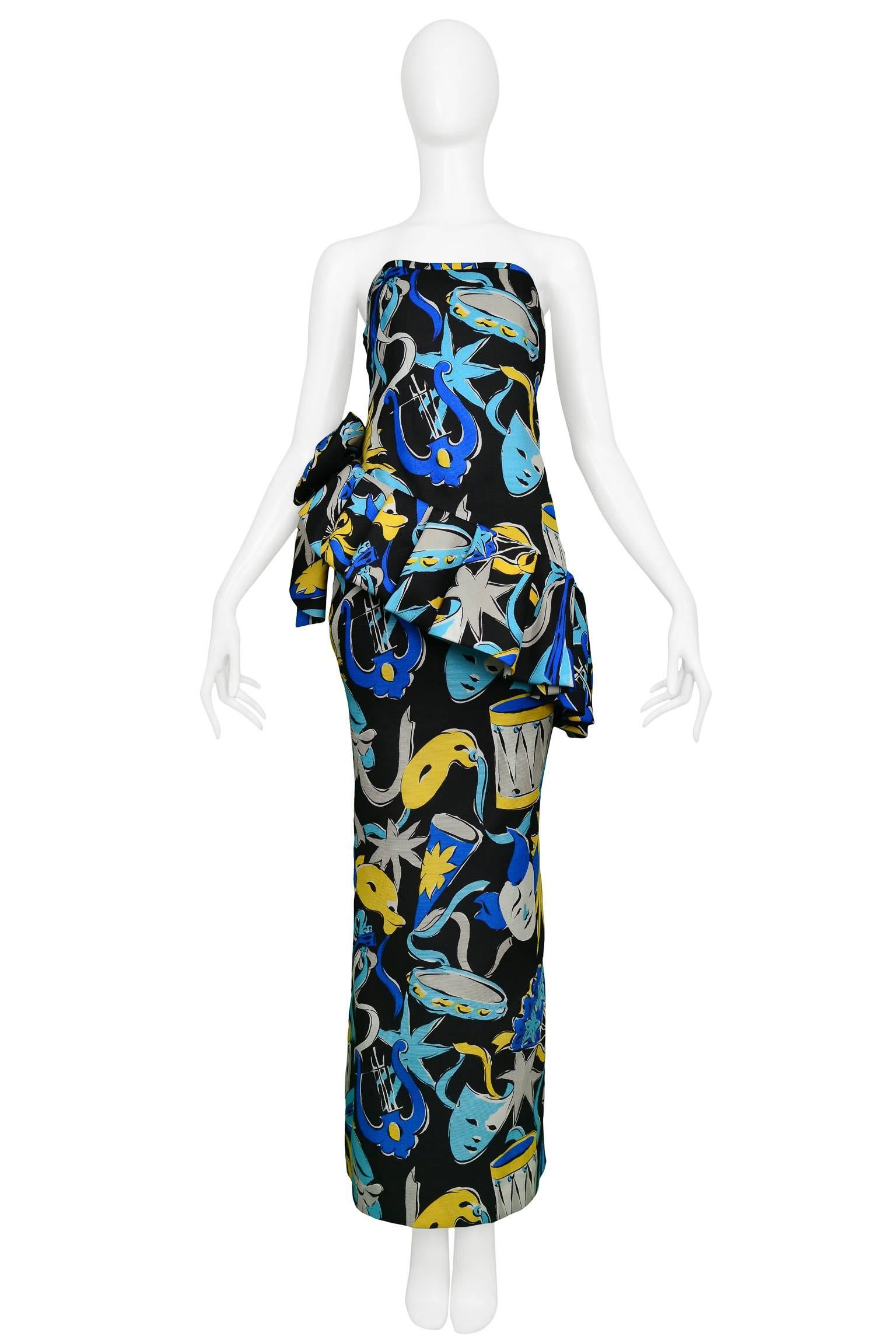 A stunning vintage Yves Saint Laurent blue, black and yellow strapless evening gown with masquerade and stars Picasso-esque print. The gown features an asymmetrical ruffle with bow at the waist.  Classic YSL.