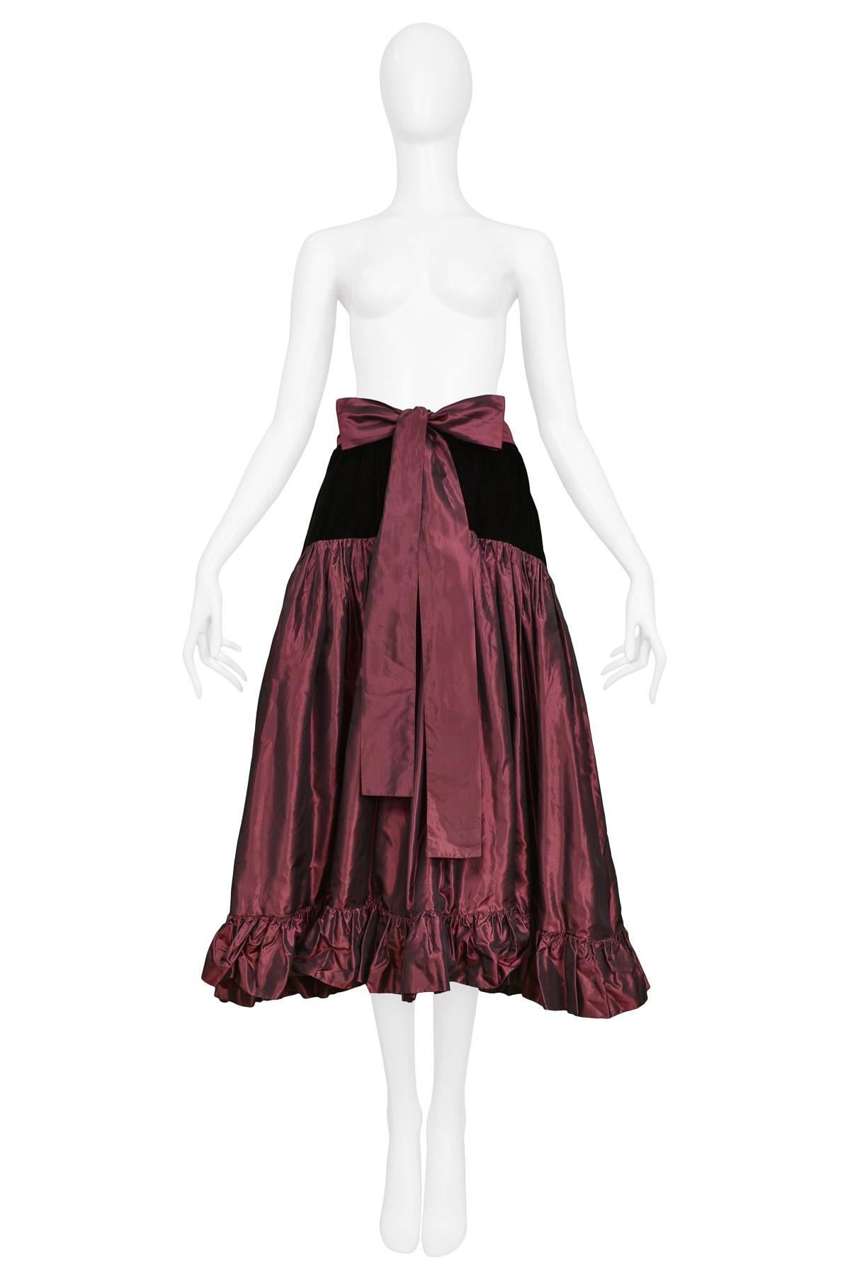 Resurrection Vintage is excited to offer a vintage Yves Saint Laurent magenta silk taffeta and black velvet party skirt featuring a high waistband, bow belt, black velvet yoke, gathered taffeta skirt with ruffles at the hem, and invisible side