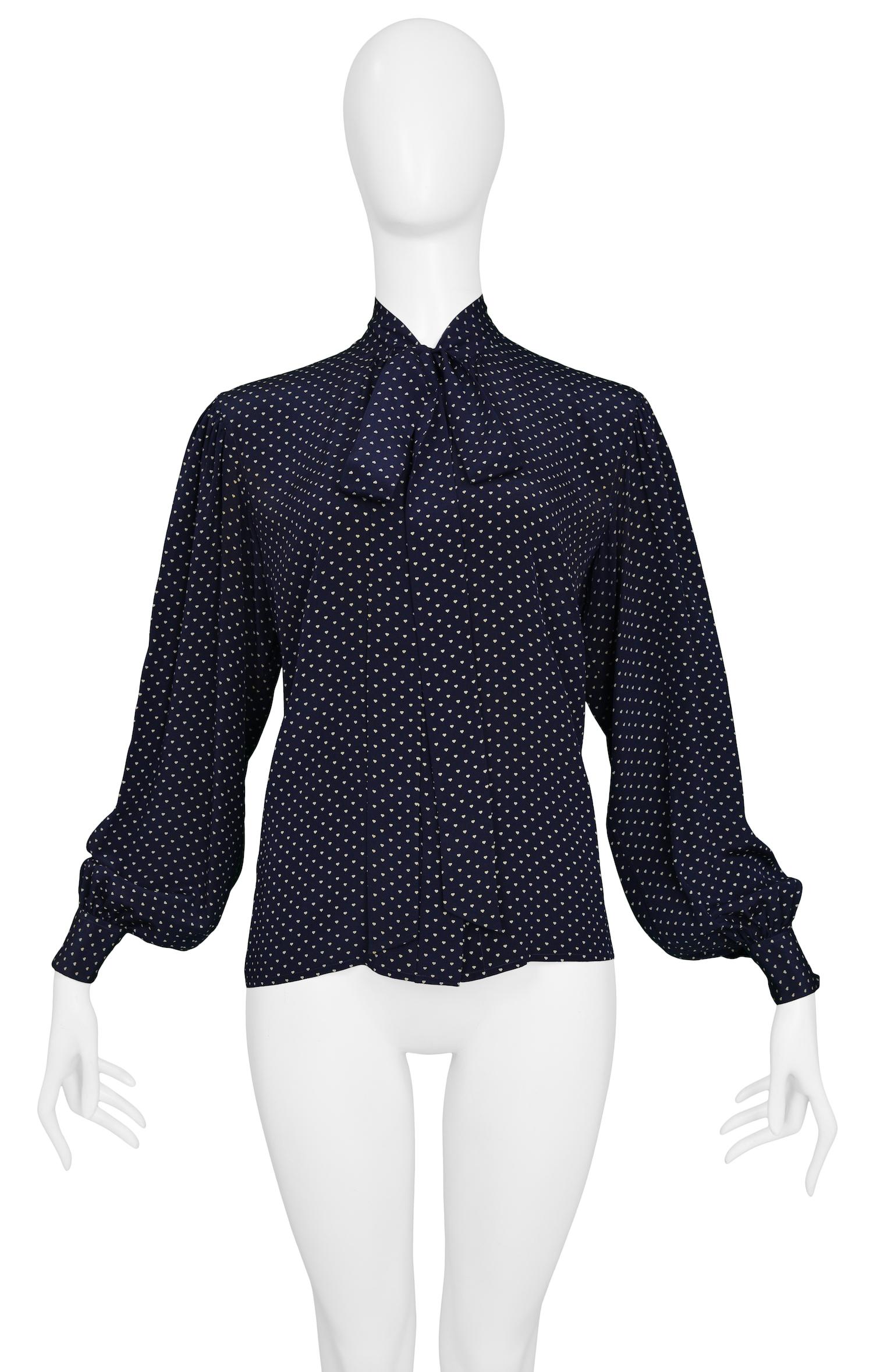 Vintage Yves Saint Laurent navy blue silk pussy bow blouse featuring delicate white hearts printed throughout. 

Excellent Condition.

Size: 42
