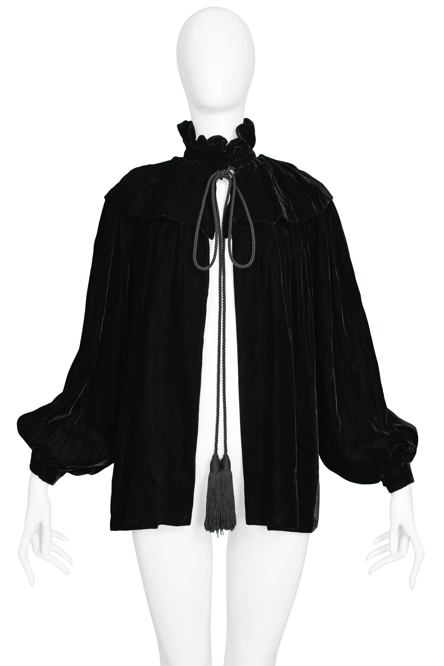 Vintage Yves Saint Laurent black velvet cloak featuring layering at shoulders, high ruffle collar, gathered wrists & tassels that tie at front closure.

Excellent Condition.

Size: 34