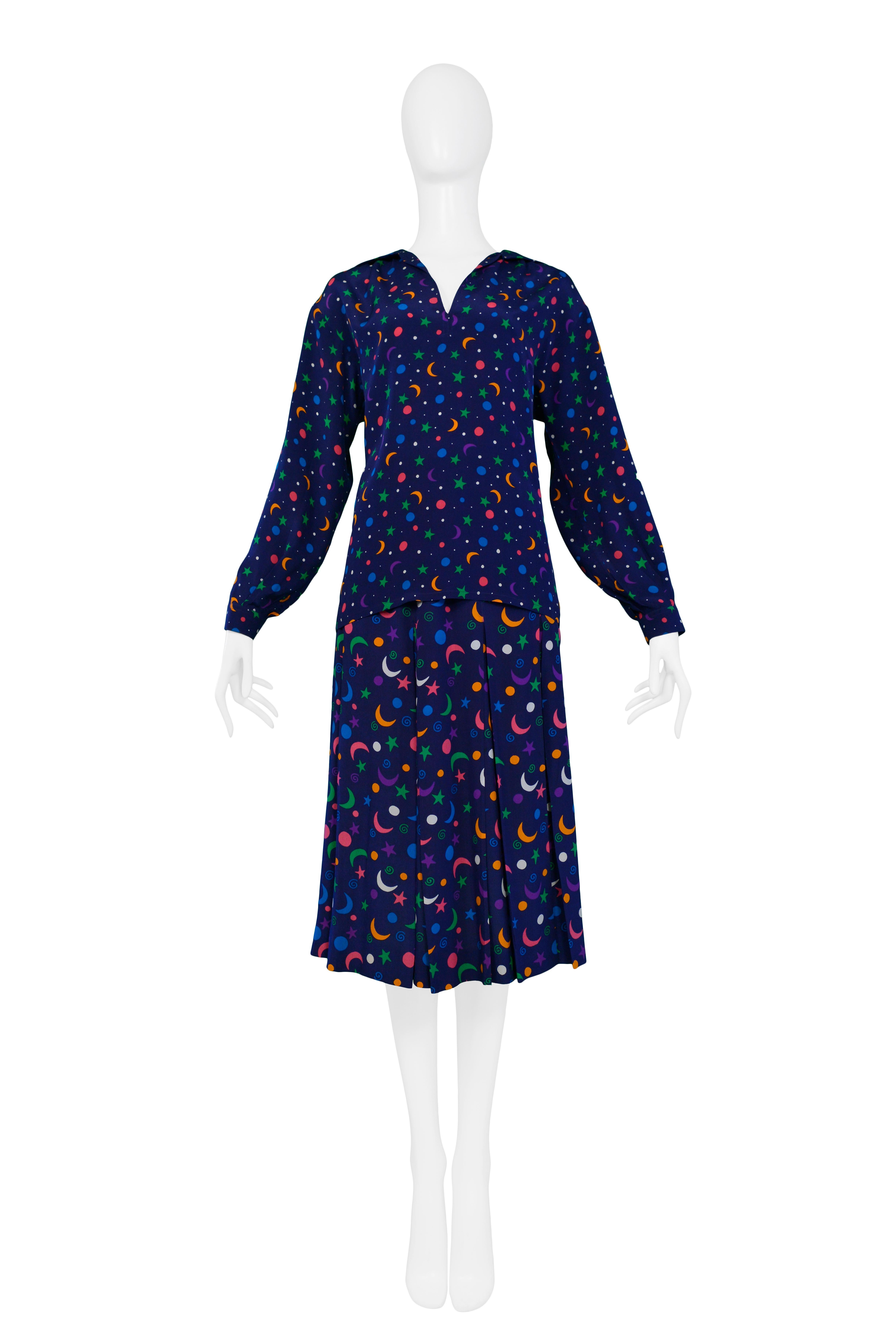 Vintage Yves Saint Laurent royal blue blouse and skirt ensemble with famous multi-color moon & star print. The set features a long sleeve open neck blouse and a matching pleated skirt. 

Excellent Condition. 

Size: TOP: 36, SKIRT: 34

