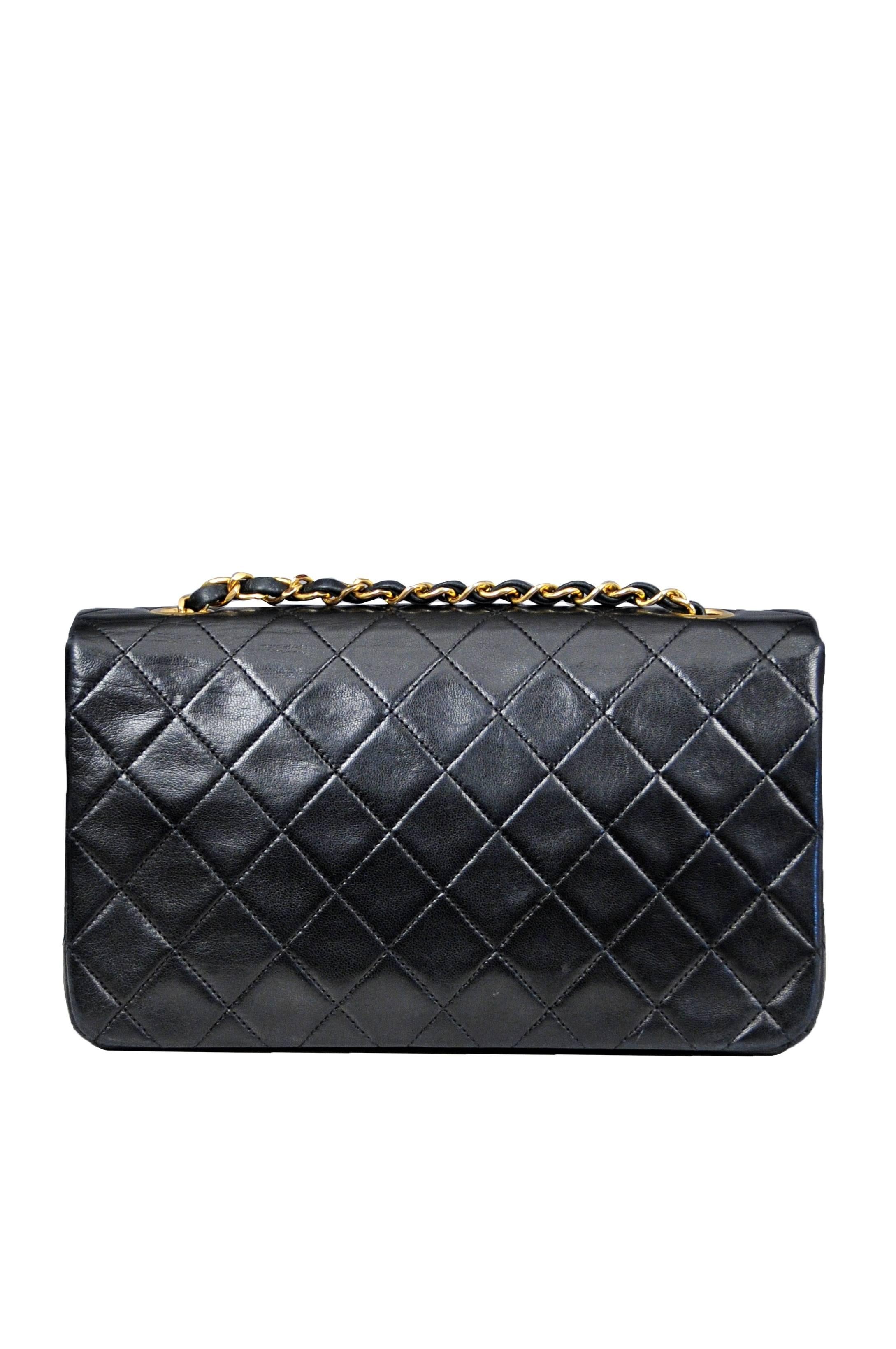 Vintage Chanel Classic three way bag in black quilted lambskin featuring burgundy leather interior lining, iconic leather and gold tone chain woven straps, two inside pockets, one inner hidden zip pocket, and a gold tone turn-lock closure at the