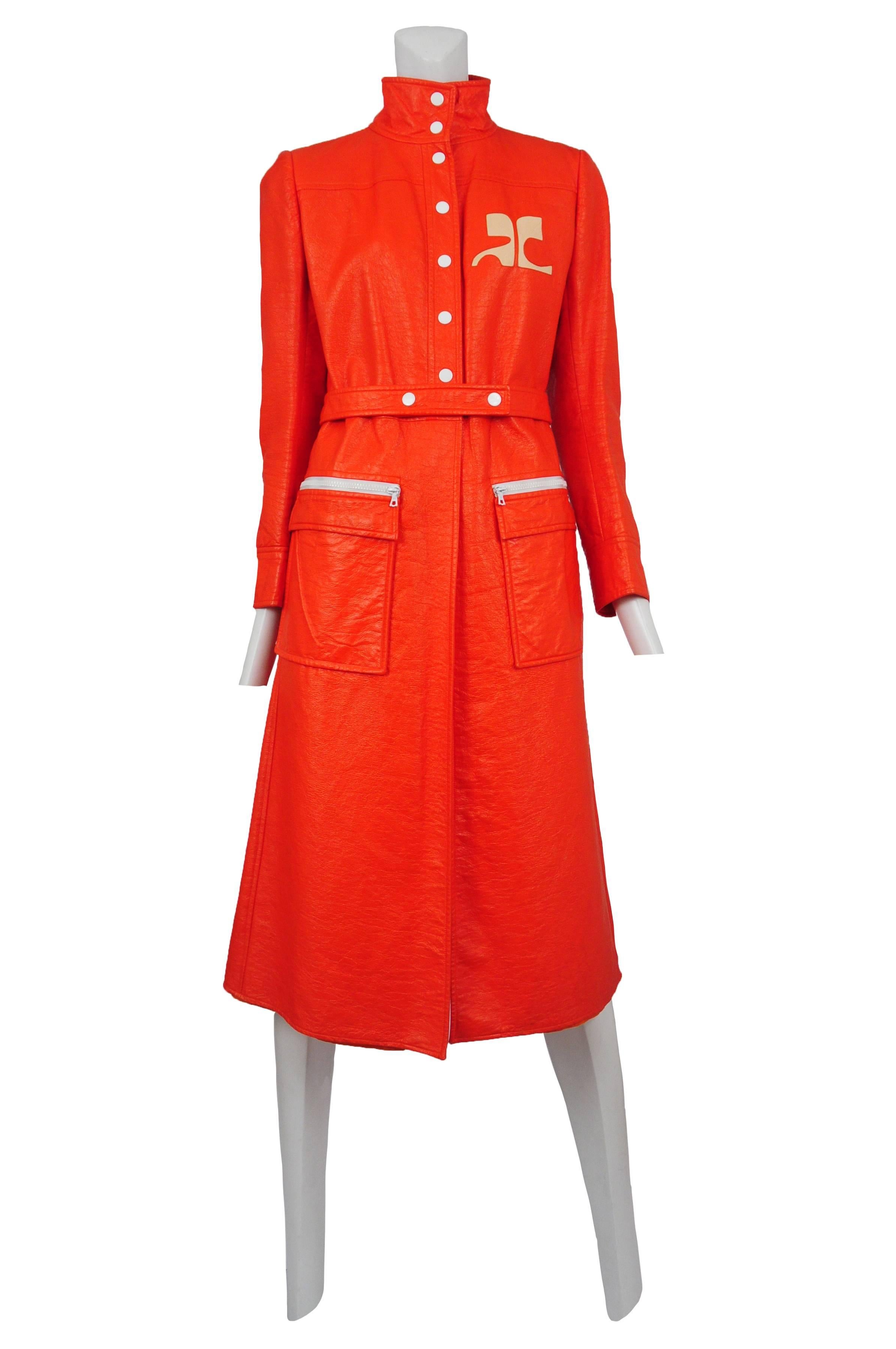 Vintage Courreges Orange vinyl trench coat with snap front closure and two front patch pockets with zip closure detail.