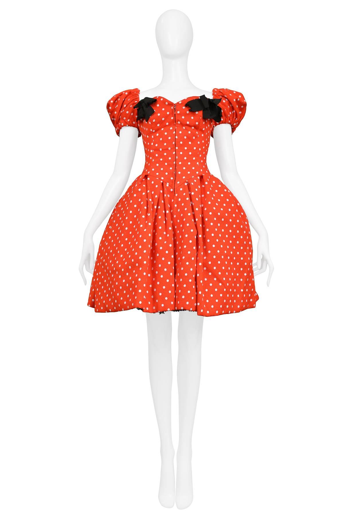 Vintage Christian Lacroix cotton blend cocktail dress featuring a red and white polka dot print, zippered front, puff sleeves, full skirt, inner corseted waist and two black grosgrain bows adorning the bust. Runway piece from the 1988 Spring/Summer