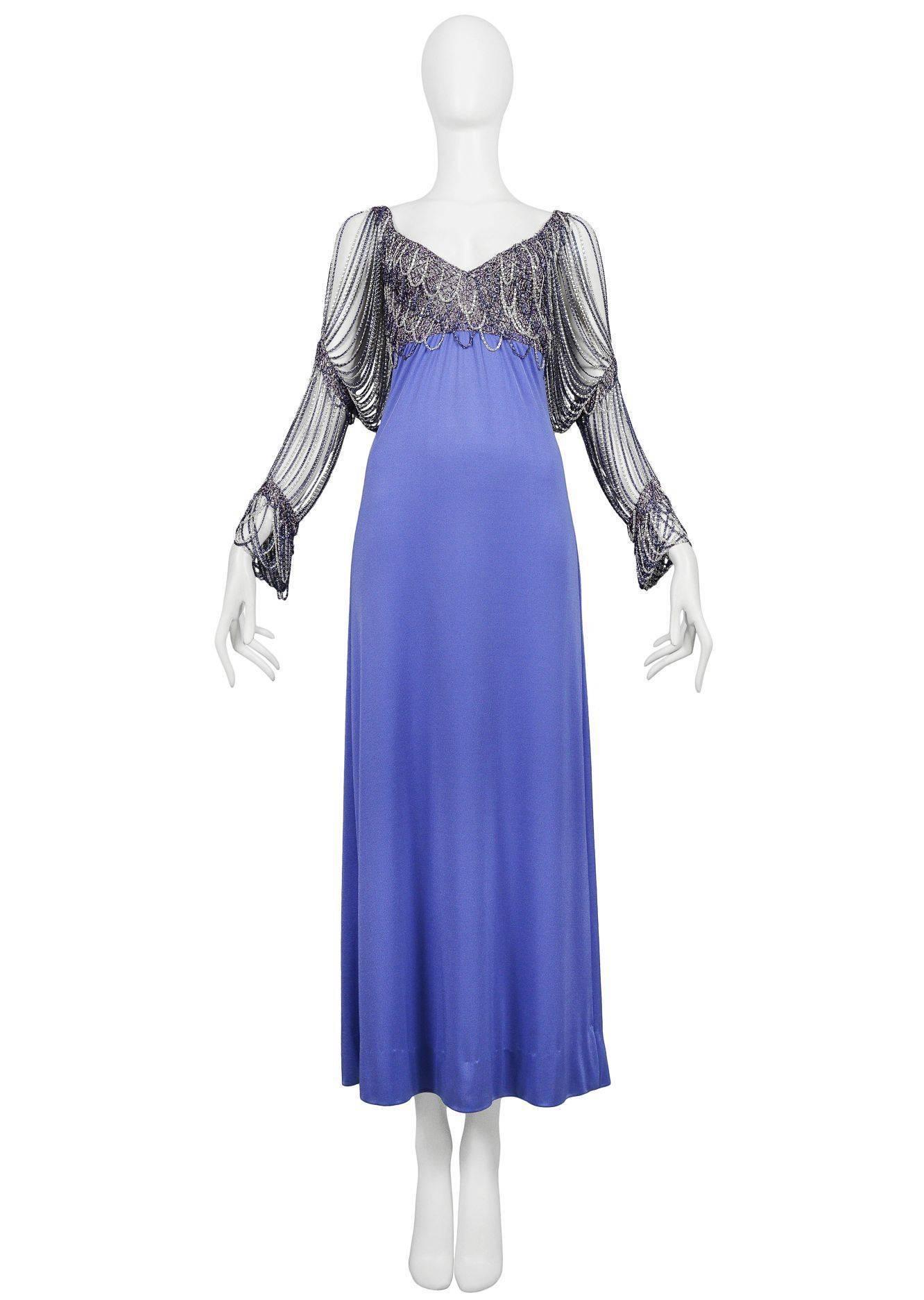 Vintage Loris Azzaro periwinkle blue maxi gown featuring a v-neckline adorned with purple and silver metal chain that extends over the bust and envelops the arms like chain linked sleeves.

Excellent Vintage Condition.