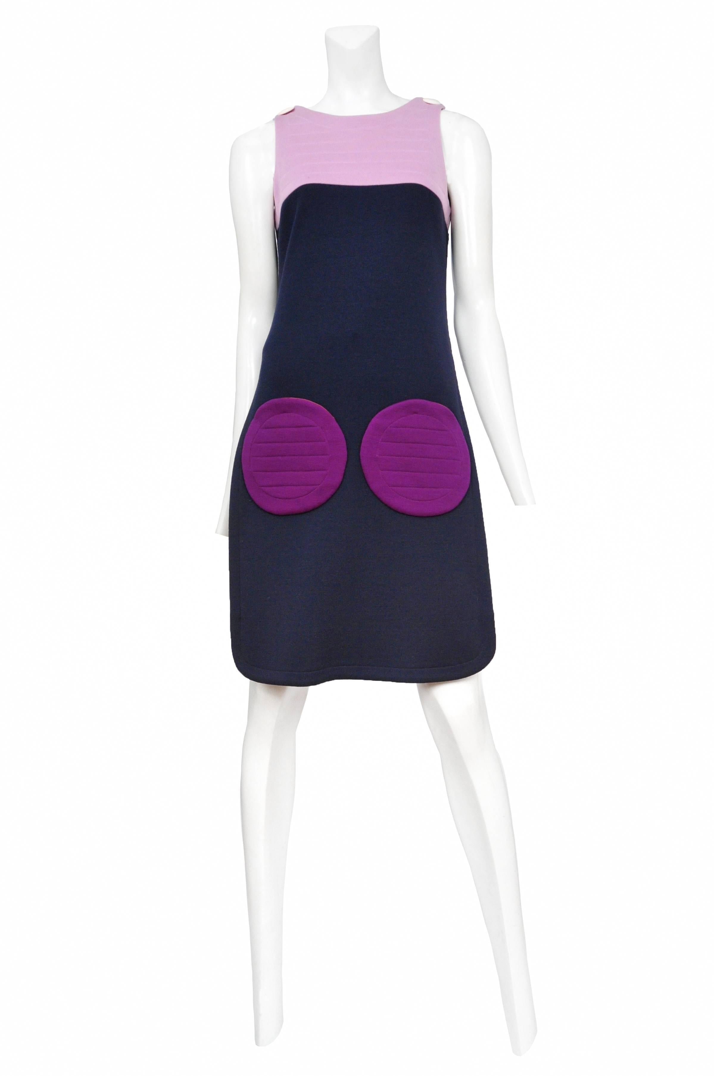 Dark purple wool mini dress with rounded skirt and neckline. Light lavender bust with horizontal top stitch detail and true purple round patch pockets at front. Zip back closure.