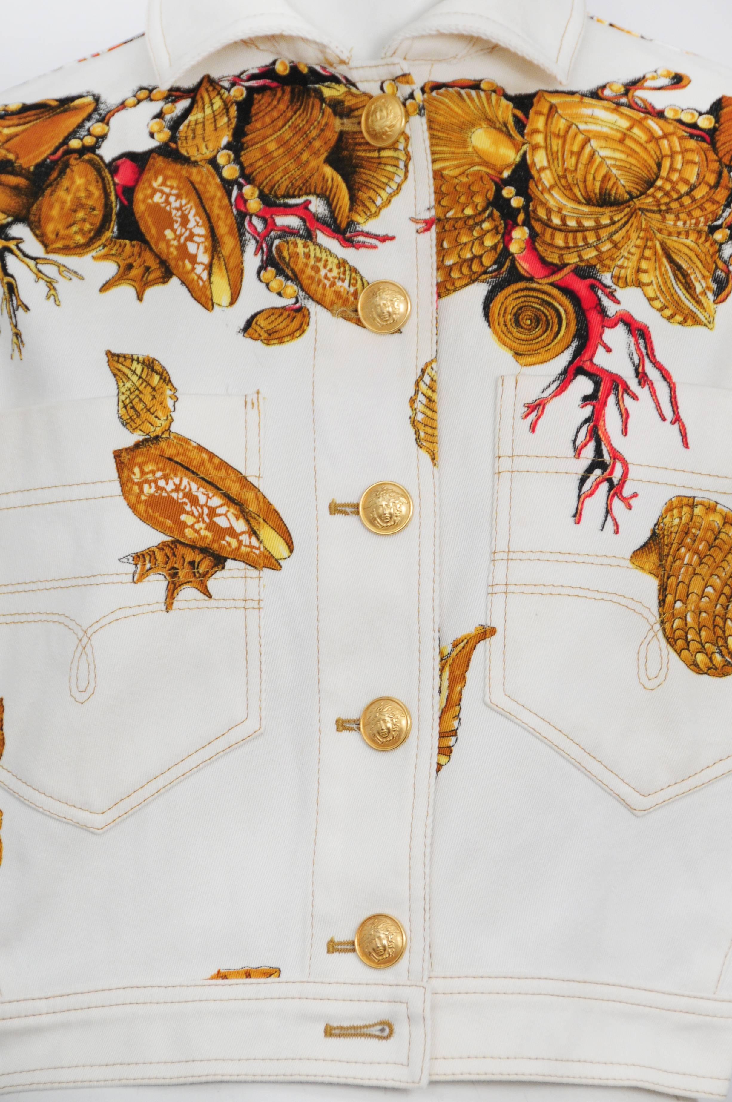 Vintage Versace white denim jacket featuring gold buttons and an all over seashell & starfish motif print. Circa 1992