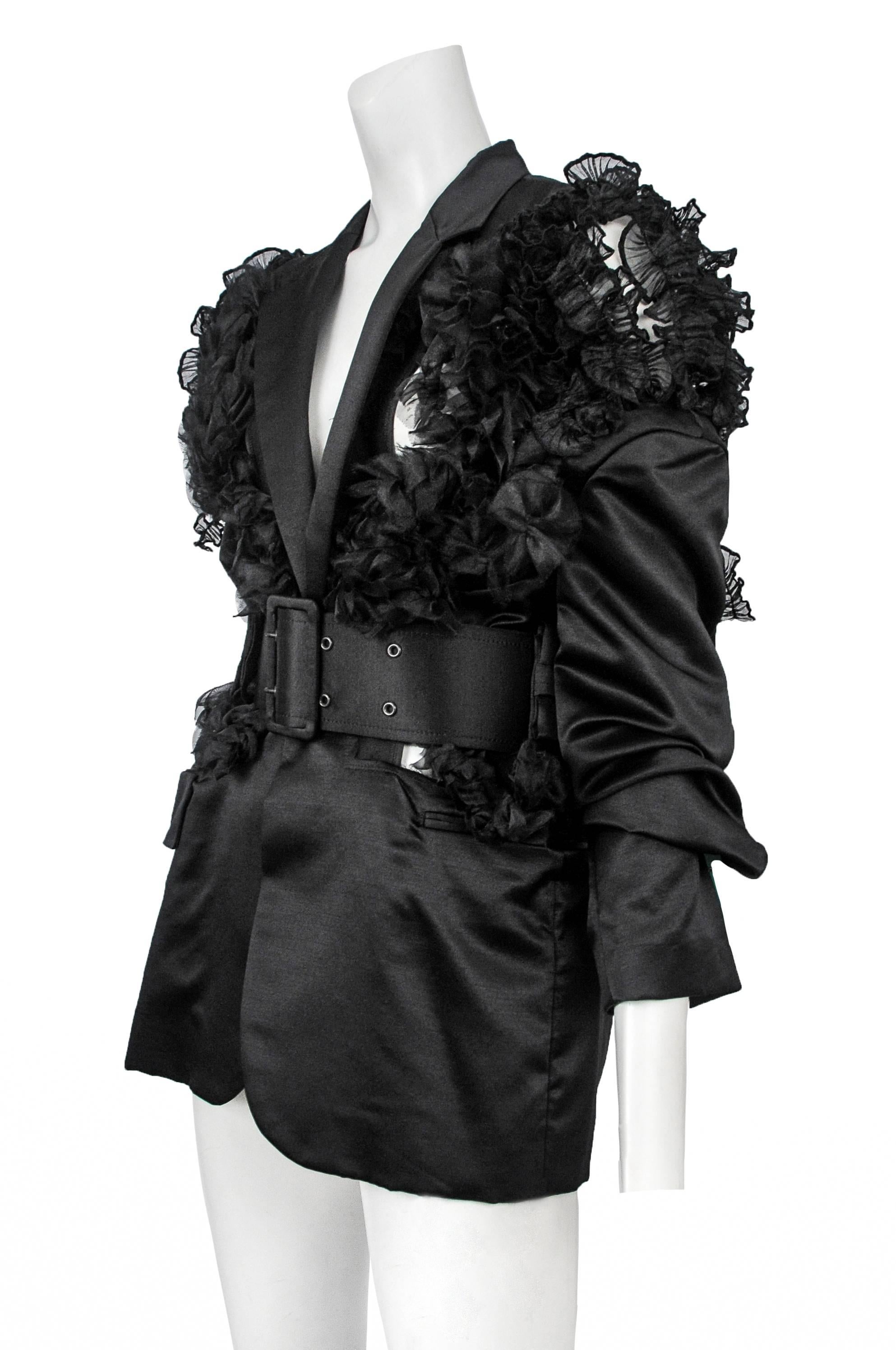 Vintage Comme des Garcons black satin pointed lapel blazer featuring ruffle organza detailing at the shoulders and torso and a matching wide buckle satin belt. Circa 2006.