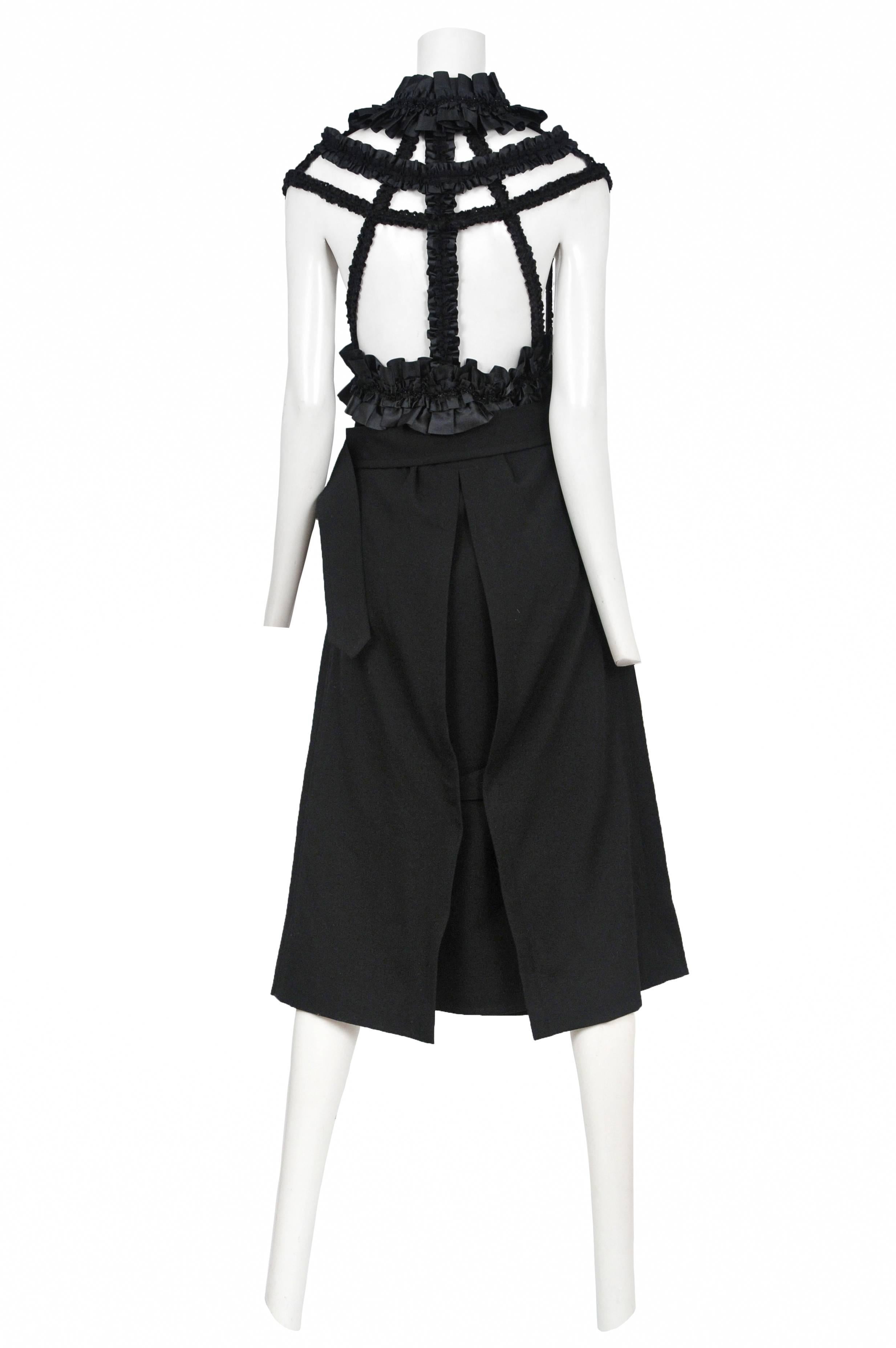 Vintage Comme des Garcons black ribbon harness dress featuring black satin ribbon gathered at harness, neck, and waist band and attaches to a faux double breasted mid length skirt. Circa 2008. 
