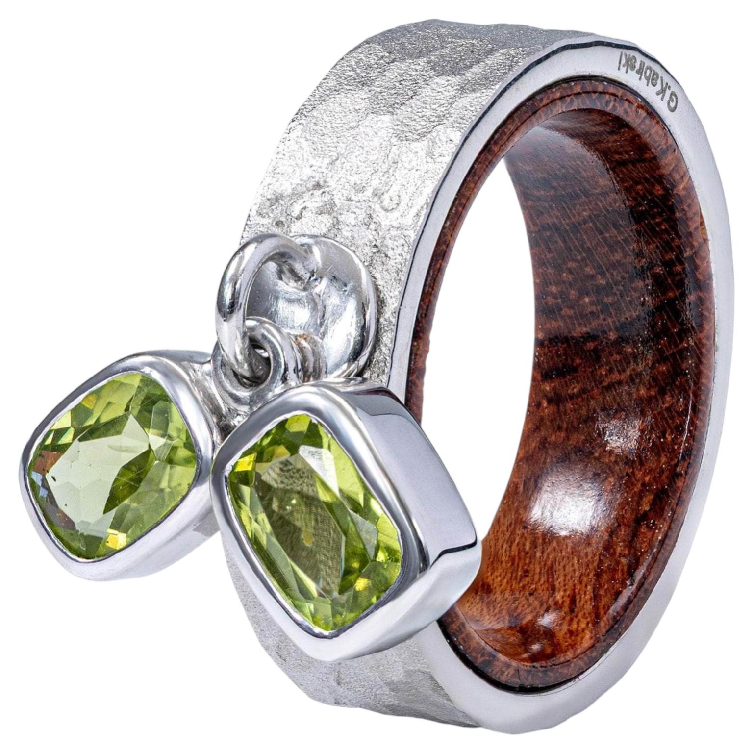 Anillo alemán «Kabirski Sylphs» de plata y palisandro con dos peridotos de talla octogonal