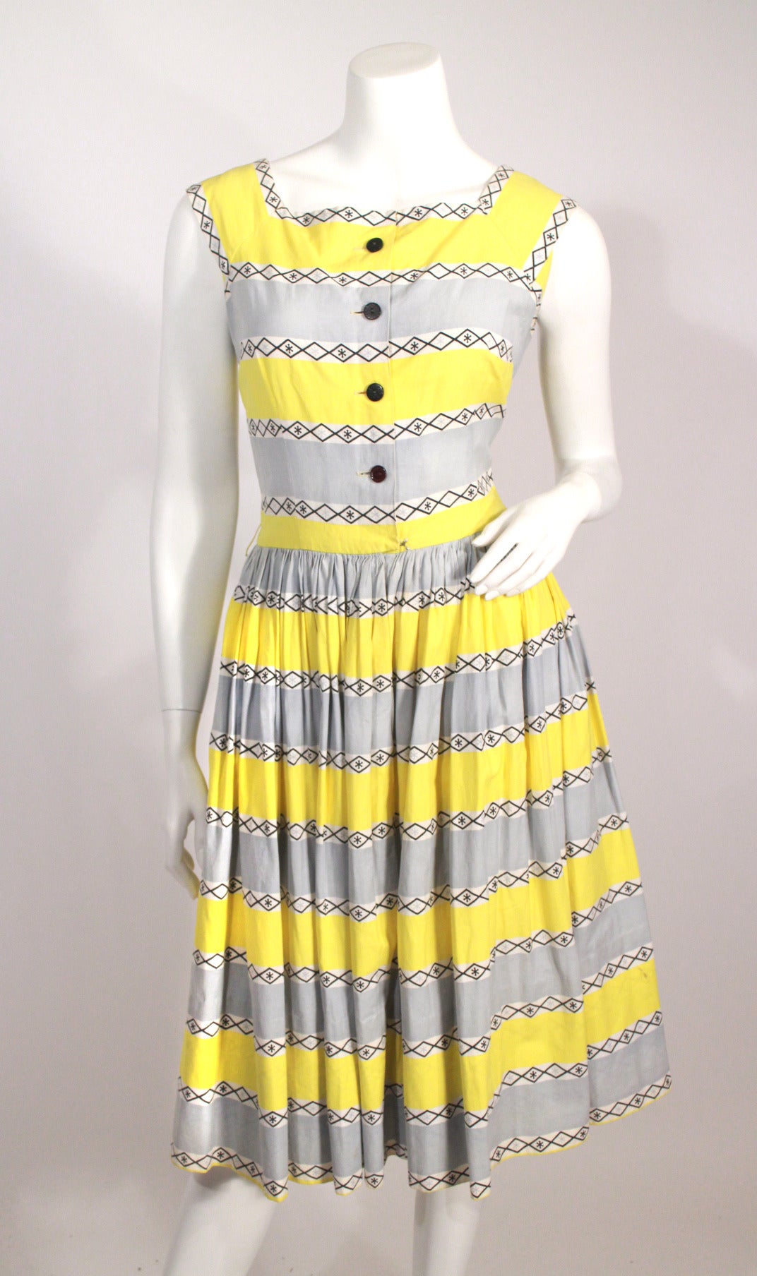 Vintage 1950s yellow and grey print day dress. Truly sweet print, buttons up the front, waist closure.