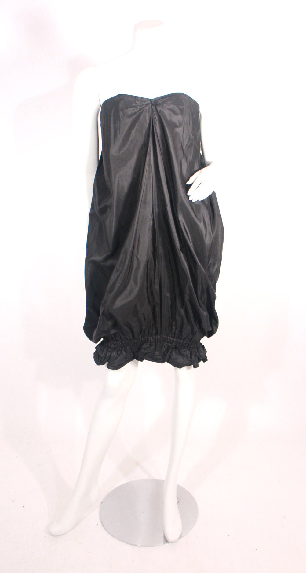 Iconic vintage 1980s Yves Saint Laurent rive gauche runway pouf/ puffer dress. Black iridescent strapless dress featuring an oversized bow on the backside, bubble dress style can be worn short or long. There is a boned bustier first layer. Extremely
