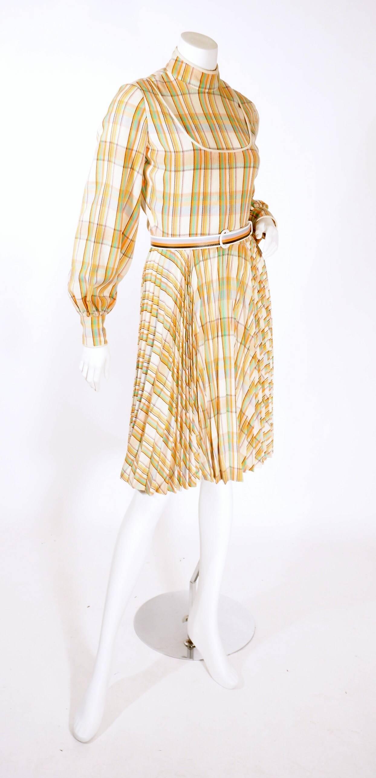 1970's Galanos multi- colored plaid dress. This fun colorful dress features a high neckline, with a vest/shirt illusion and a built-in belt. Wide l/s sleeves with tapered cuffs with buttons and a pleated skirt. Zip back with buttons. 

Excellent