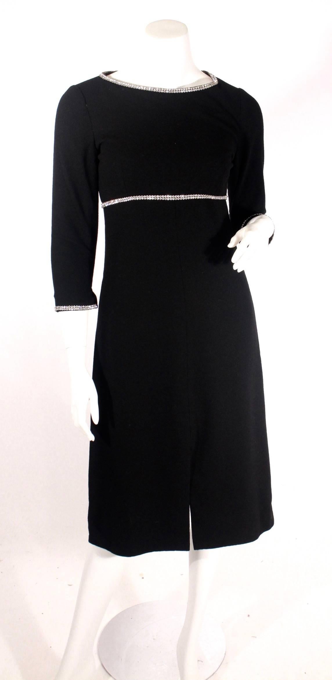Vintage Norman Norell black wool crepe evening dress. This dress features an empire waist, rhinestone trim around the neckline and waist. Excellent condition. 