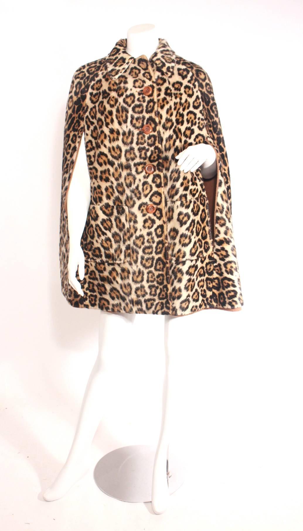 Vintage Faux leopard fur cape and its reversible!! Amazing shape, chic style, buttons up the front with two pockets. Perfect transition piece into fall/winter!