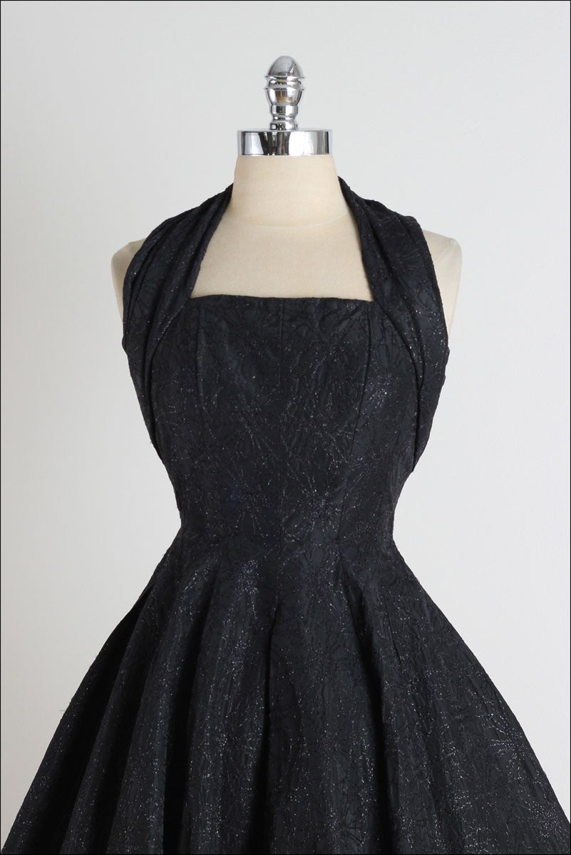 ➳ vintage 1950s dress

* black taffeta
* metallic floral stitching
* halter neck
* boning in bodice
* full skirt
* metal back zipper
* by Suzy Perette

condition | excellent

fits like xs

length 41