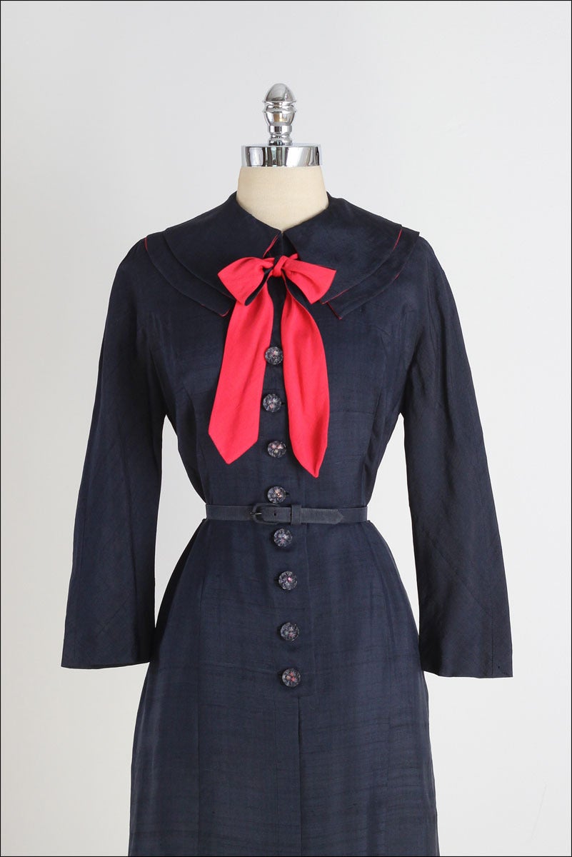 ➳ vintage 1940s dress

* navy blue semi sheer silk
* reversible red bow tie
* red silk lined collar
* detached belt
* front pockets
* button front
* by Eisenberg Originals

condition | excellent

fits like m/l

length 42