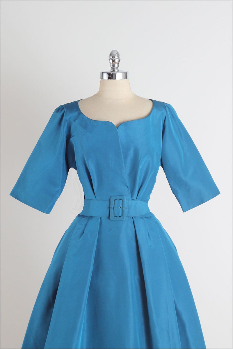 ➳ vintage 1950s dress

* teal blue silk taffeta
* organza lining
* 3/4 sleeve
* detached belt
* metal back zipper
* by Christian Dior

condition | excellent

fits like m/l

length 44