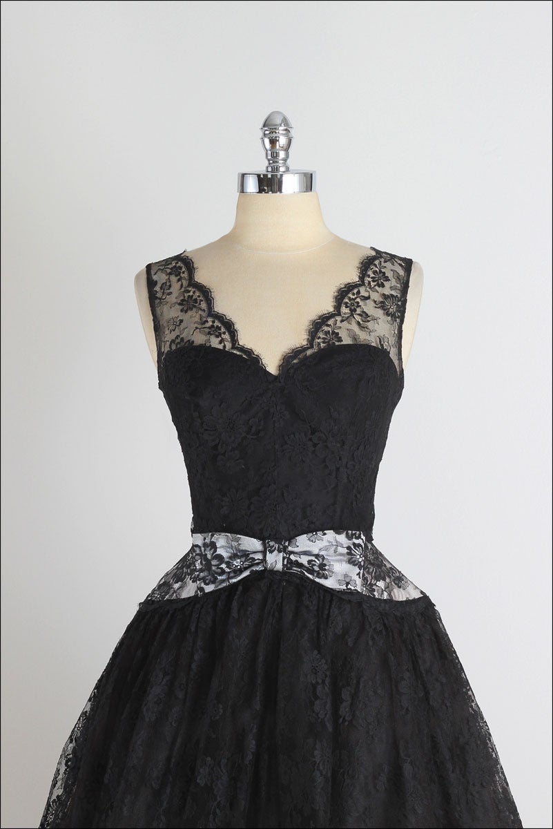 ➳ vintage 1950s dress

* black lace
* acetate/tulle lining
* white bow waist
* boning in bodice
* metal back zipper

condition | excellent

fits like small

length 46