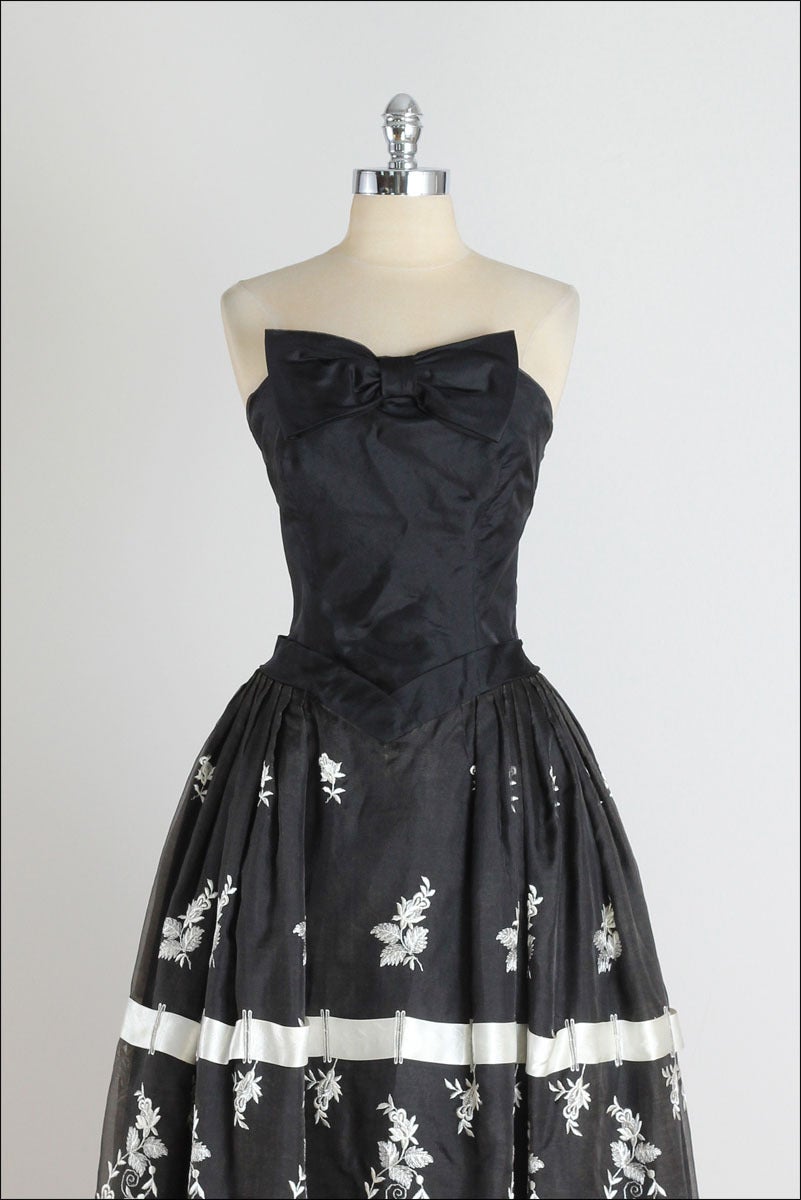 ➳ vintage 1950s dress

* black organza
* acetate lining
* white floral embroidery
* satin ribbon woven in skirt
* metal back zipper

condition | excellent

fits like m/l

length 43