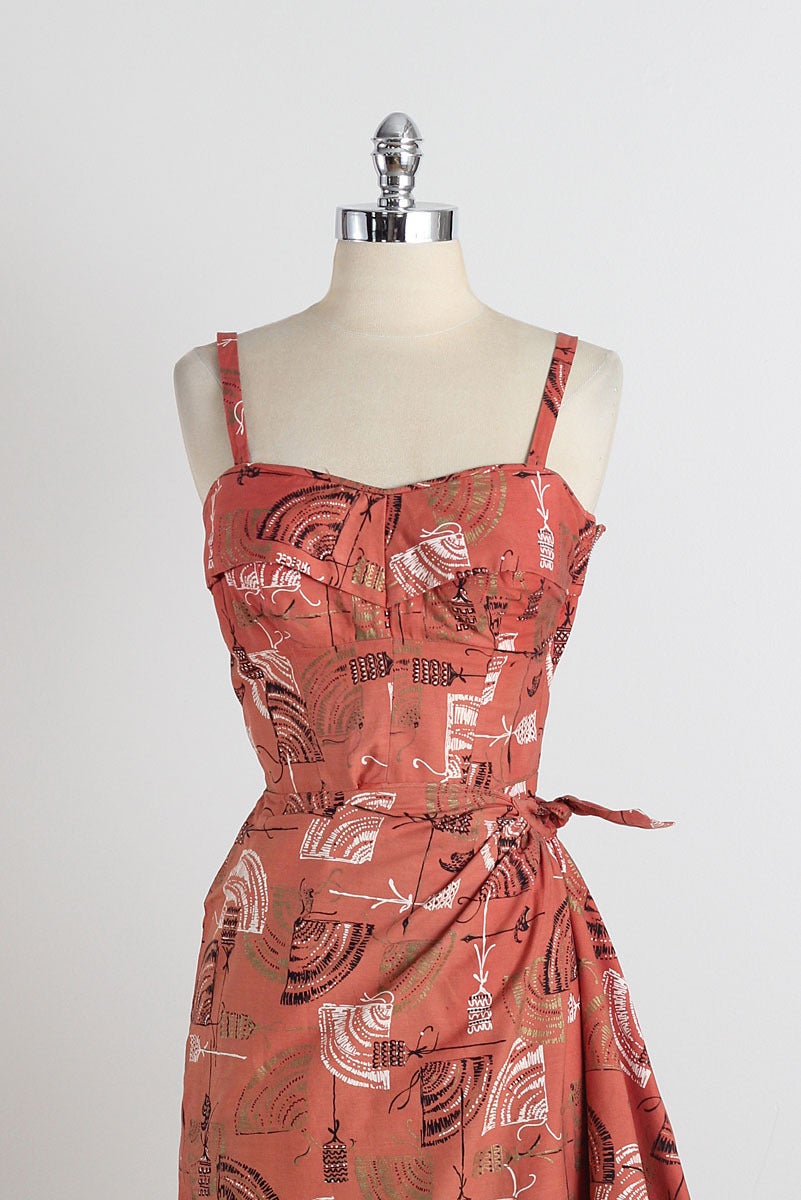 ➳ vintage 1950s dress

* fan print rust cotton
* cotton lined bust
* wrap style skirt
* optional straps
* metal side zipper

condition | excellent

fits like xs

length 36