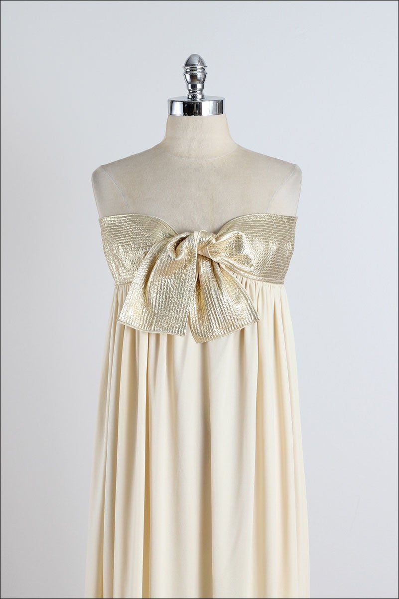 ➳ vintage 1970's dress

* gold poly jersey
* gold lame tie bust
* grecian style column dress
* by Bill Tice

condition | excellent

fits like small

length 51