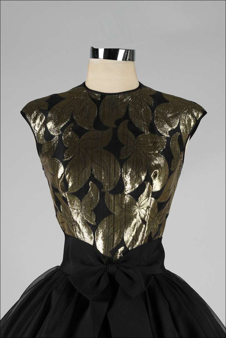 vintage 1950's dress

* metallic gold and black brocade bodice
* three full layers of organza skirt
* fitted acetate lining
* bow belt with hook/eye closure
* metal back zipper
* by Suzy Perette

condition | excellent

fits like