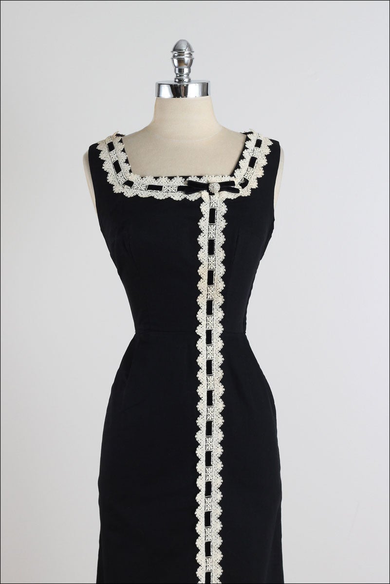 ➳ vintage 1950s dress

* black cotton pique
* white macrame floral lace 
* black velvet bow tie with rhinestone accent
* metal side zipper
* by Marcel of Miami

condition | excellent

fits like xs

length 44