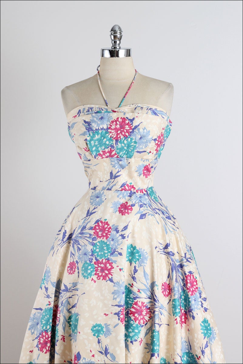 ➳ vintage 1950s dress

* cream polished cotton
* beautiful pink & blue floral print
* layered bodice
* halter straps
* metal side zipper
* by Junior Theme

condition | excellent 

fits like xs/s

dress length 39