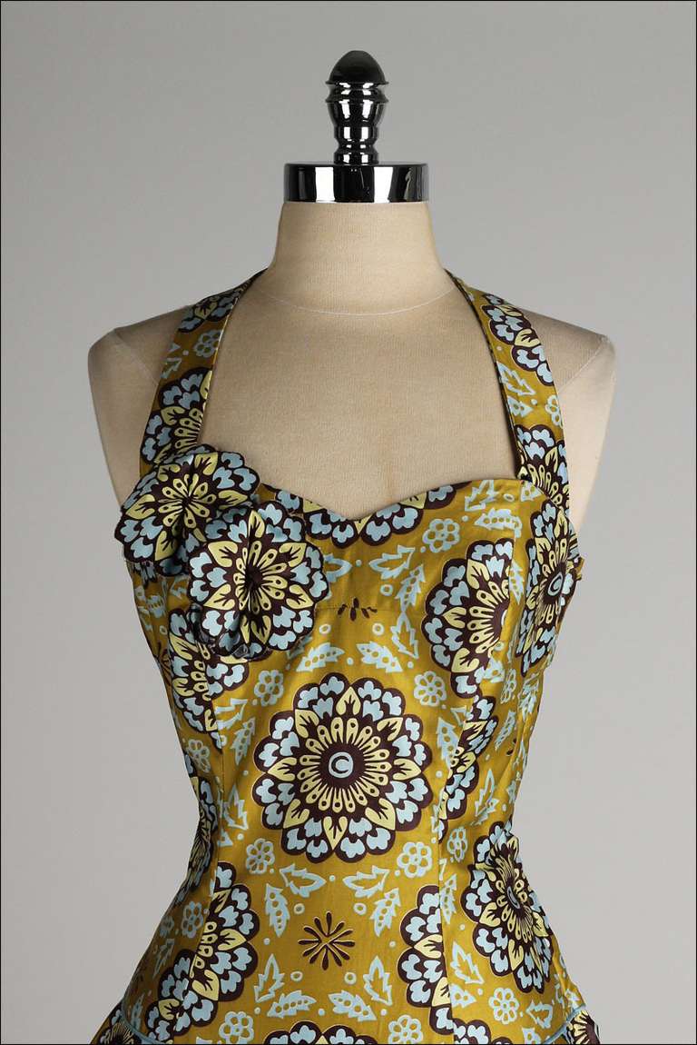 vintage 1950s dress

* bold print polished cotton
* blue piping on waist
* flower rosettes on bust
* metal side zipper
* halter strap unsnaps to remove for strapless look
* by Shayne of Miami

condition | excellent

fits like