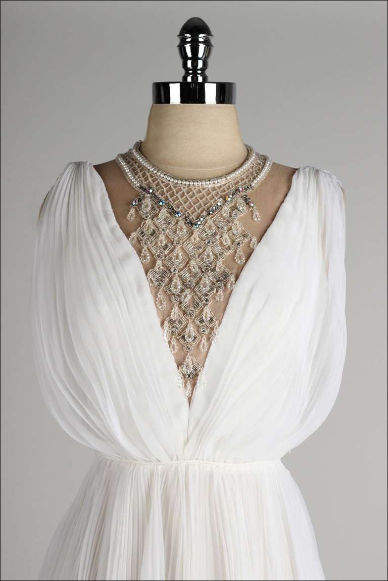 ➳ vintage 1960's dress

* ivory crepe chiffon
* nude nylon lining
* amazing rhinestone/beadwork bib collar
* illusion bodice
* back zipper
* accordion pleat skirt
* by Jack Bryan

condition | excellent

fits like xs

length 37