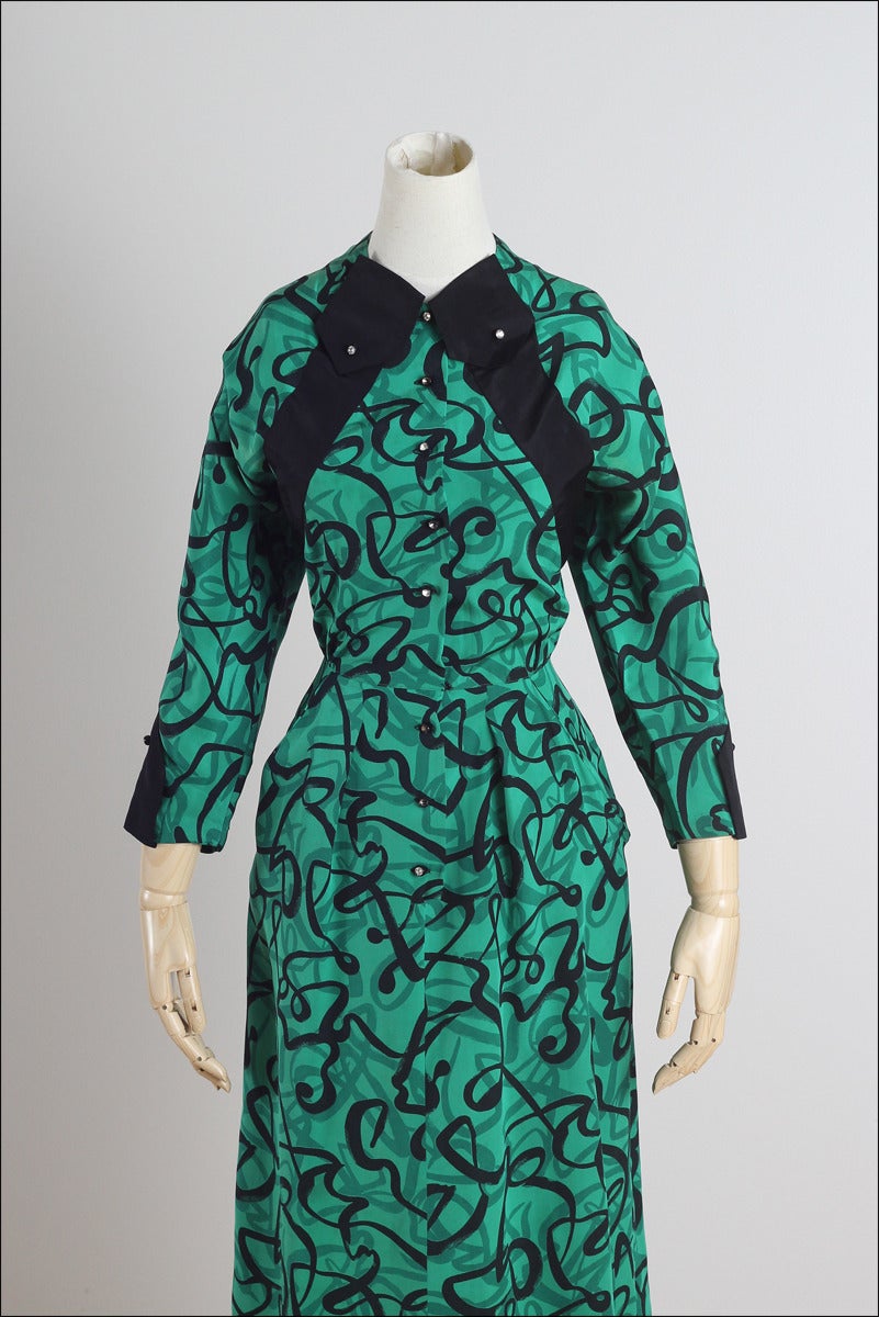 ➳ vintage 1940s dress

* green abstract print silk
* rhinestone button front
* black silk accents on bodice & sleeves
* pockets

condition | excellent 

fits like xs/s

dress length 46