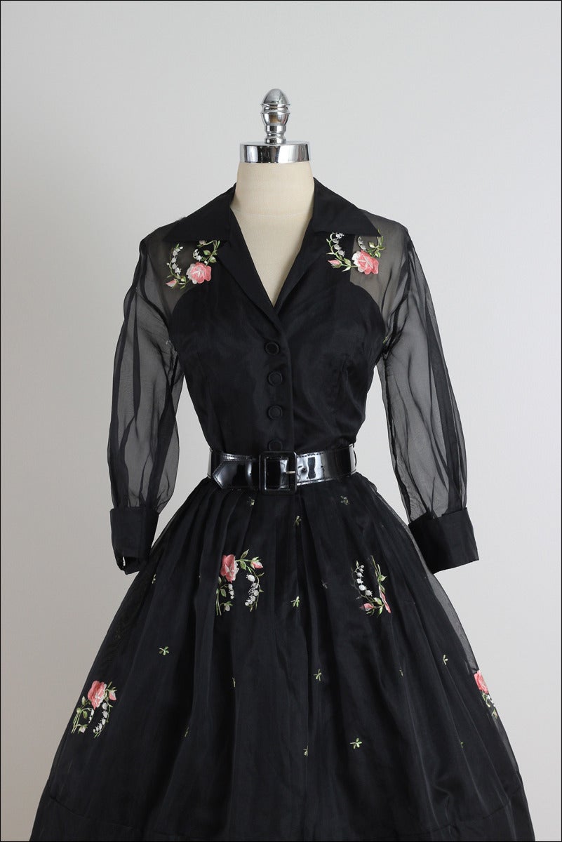 ➳ vintage 1950s dress

* black organza
* acetate & tulle lining
* button front
* pink floral embroidery
* semi sheer sleeves
* detachable belt

condition | excellent

fits like medium

length 45