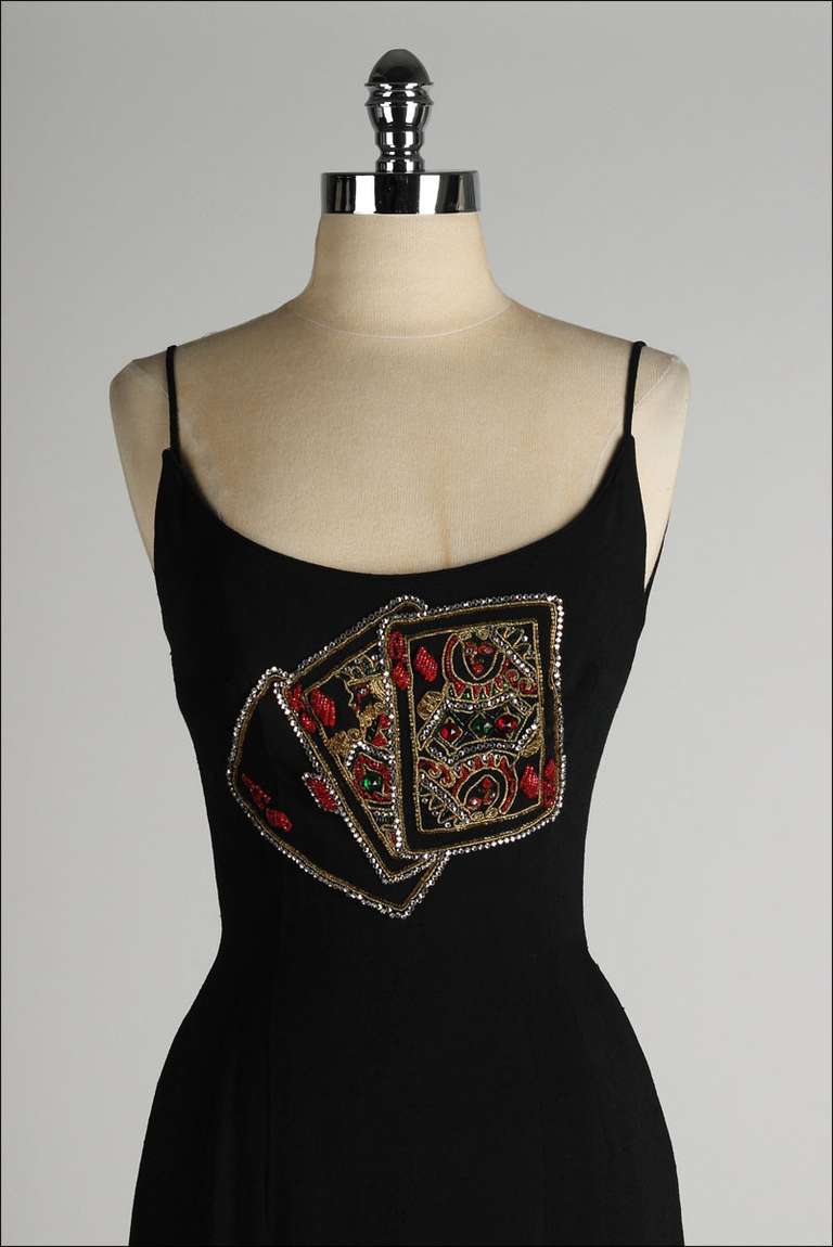 ➳ vintage 1950's dress

* black rayon blend
* acetate lining
* rhinestone/beaded playing card motif
* spaghetti straps
* boning in bodice
* back zipper
* by Mr. Blackwell Design

condition | excellent

fits like xs

length 41
