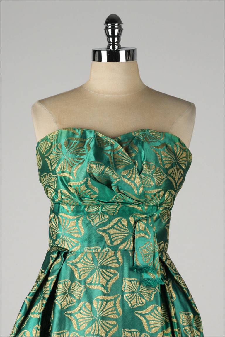 ➳ vintage 1950's dress

* green silk satin
* muslin lined bodice
* mesh lined skirt
* metallic gold print
* strapless
* boning in bodice
* metal back zipper
* by Helena Barbieri

condition | excellent

fits like medium

length