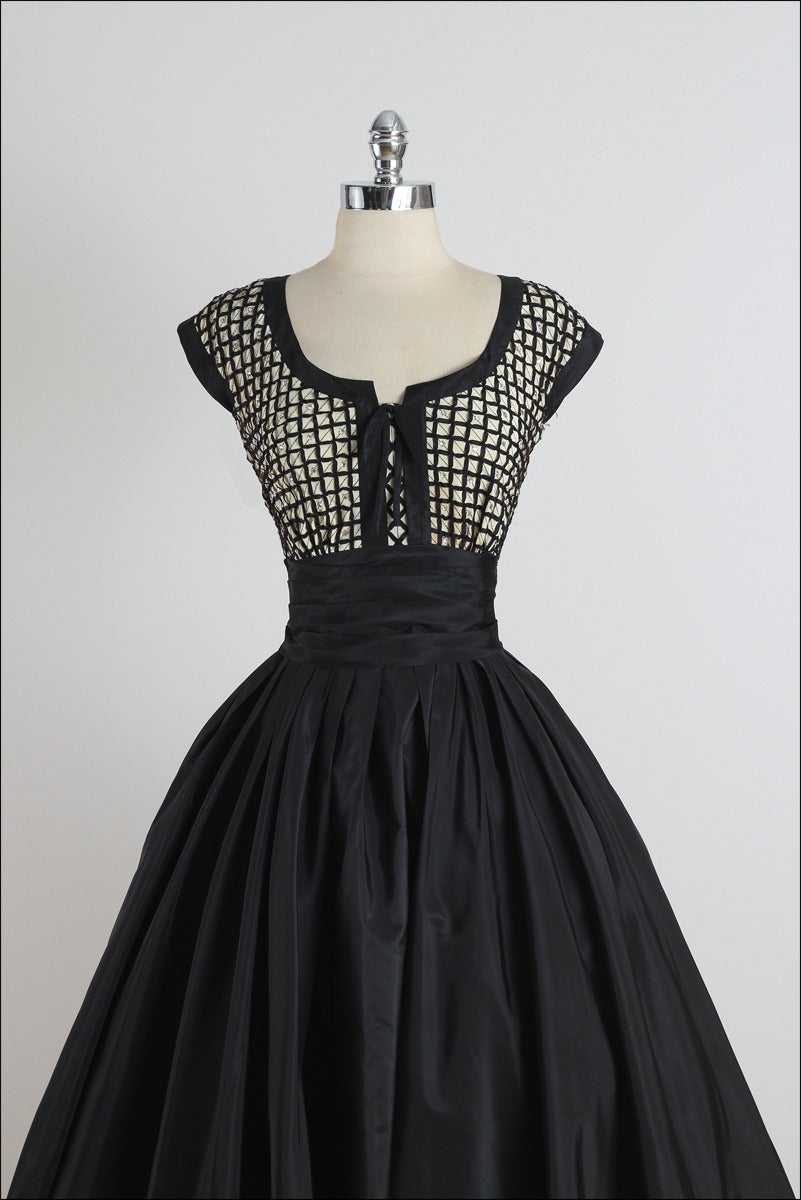 ➳ vintage 1950s dress

* black taffeta
* criss-cross ribbon bodice
* rhinestone accents
* gathered belt
* metal side zipper
* by Paul Sachs

condition | excellent

fits like xs/s

length 48 
bodice 14
