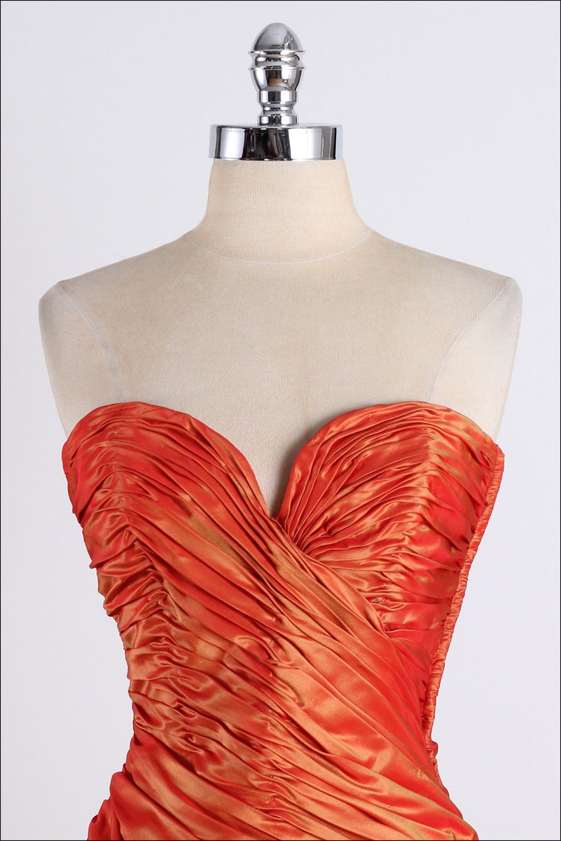 vintage 1980's dress

* iridescent orange silk
* shirred/strapless
* bow at hip
* boning in bodice
* back zipper
* by Vicky Tiel Couture

condition | excellent

fits like xs/s

length 30