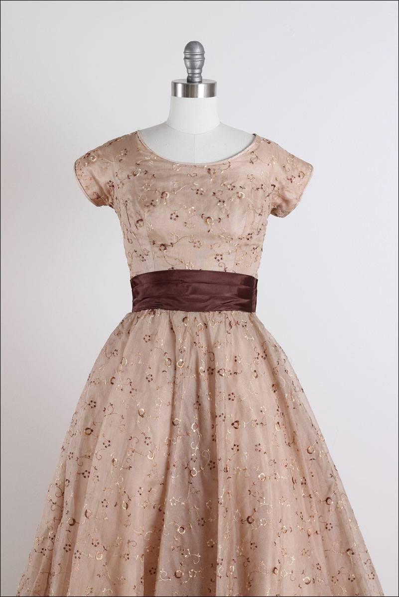 ➳ vintage 1950s dress

* light brown organza
* tulle/ acetate lining
* gold/ brown embroidered accents
* sash waist with tail
* balloon hem
* metal side zipper

condition | excellent

fits like xs/s

length 44
