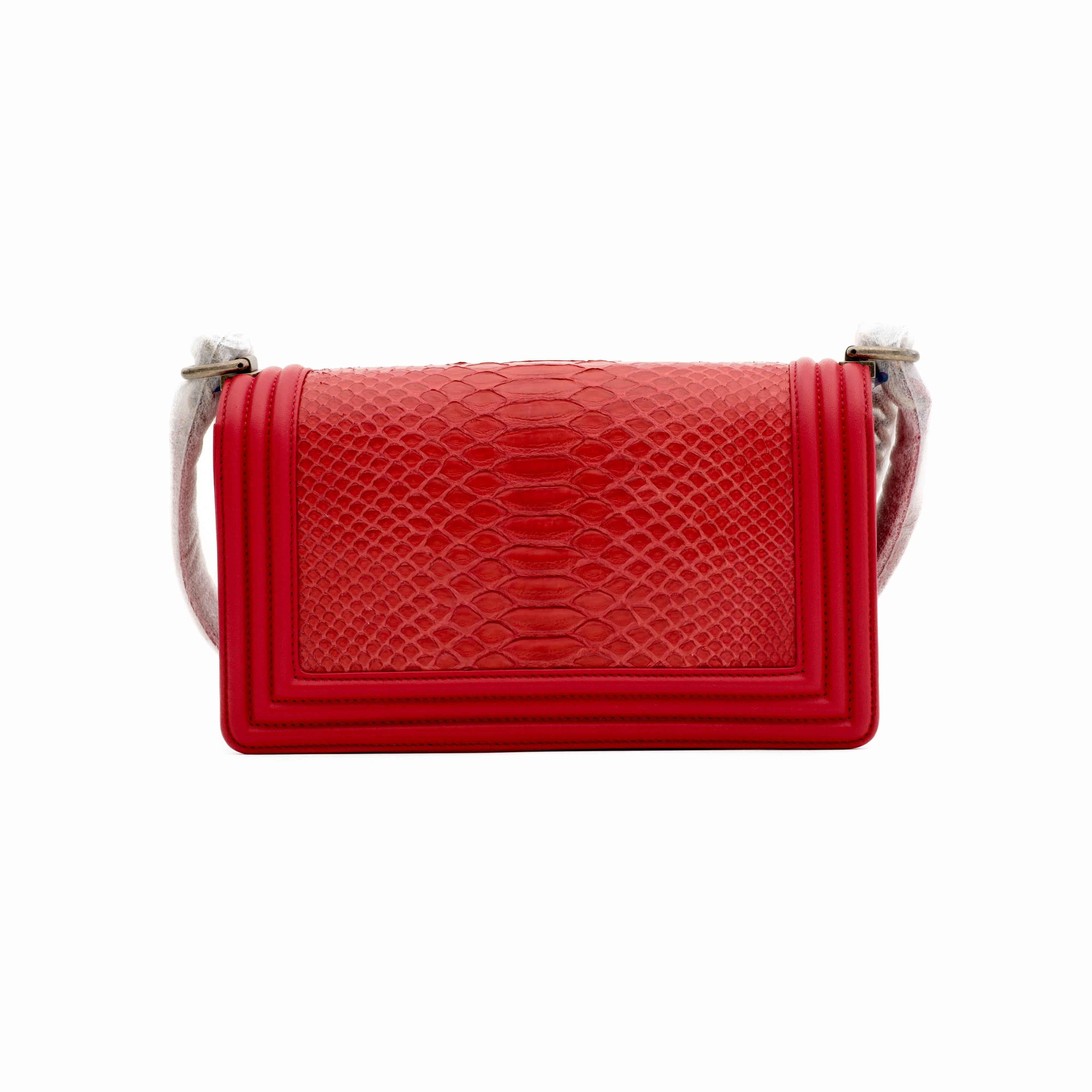 Chanel Medium Boy bag made of red python with calf leather and antique gold tone hardware.
 
This bag features a full front flap with the signature Le Boy CC push lock closure and a chain link, and leather shoulder/crossbody strap.
 
The