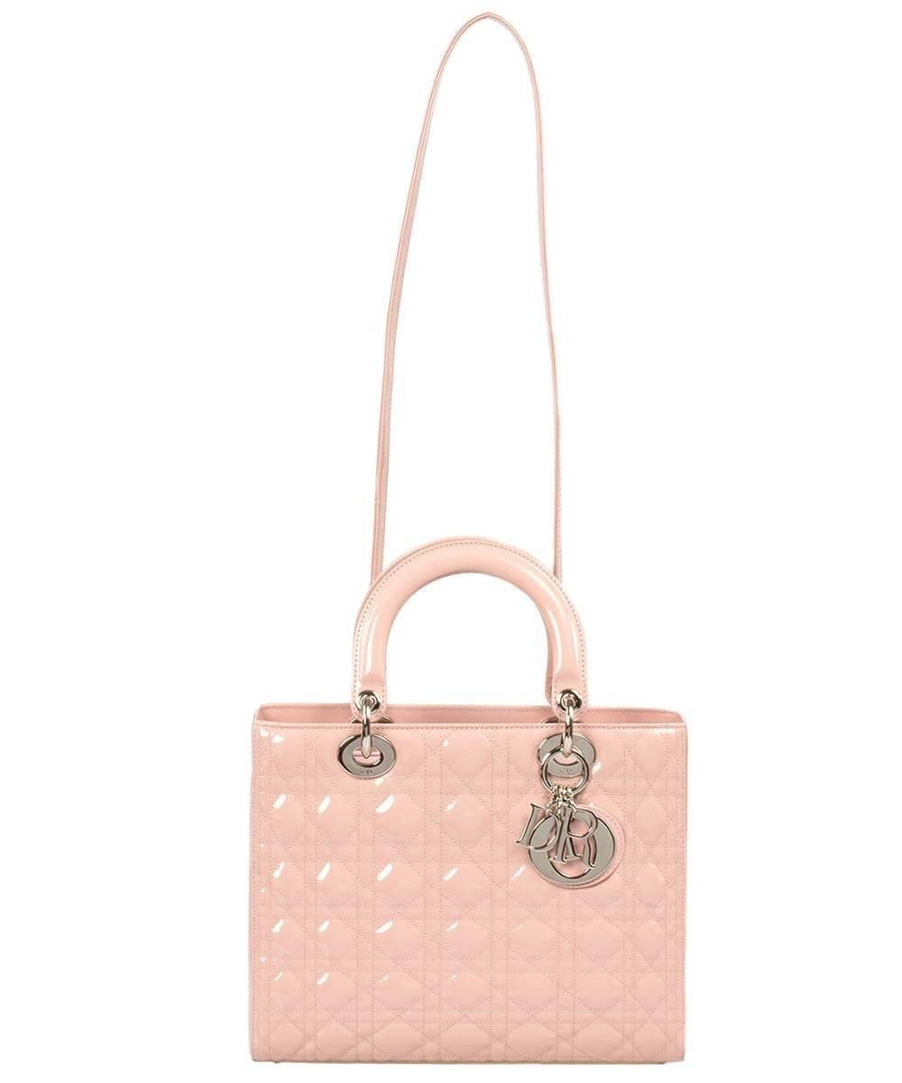 An unparalleled work of art, this pink Lady Dior Patent Leather Bag is meticulously handcrafted utilizing high quality shiny and smooth patent leather from the legendary design house Christian Dior. The bag's timeless look consists of Dior's