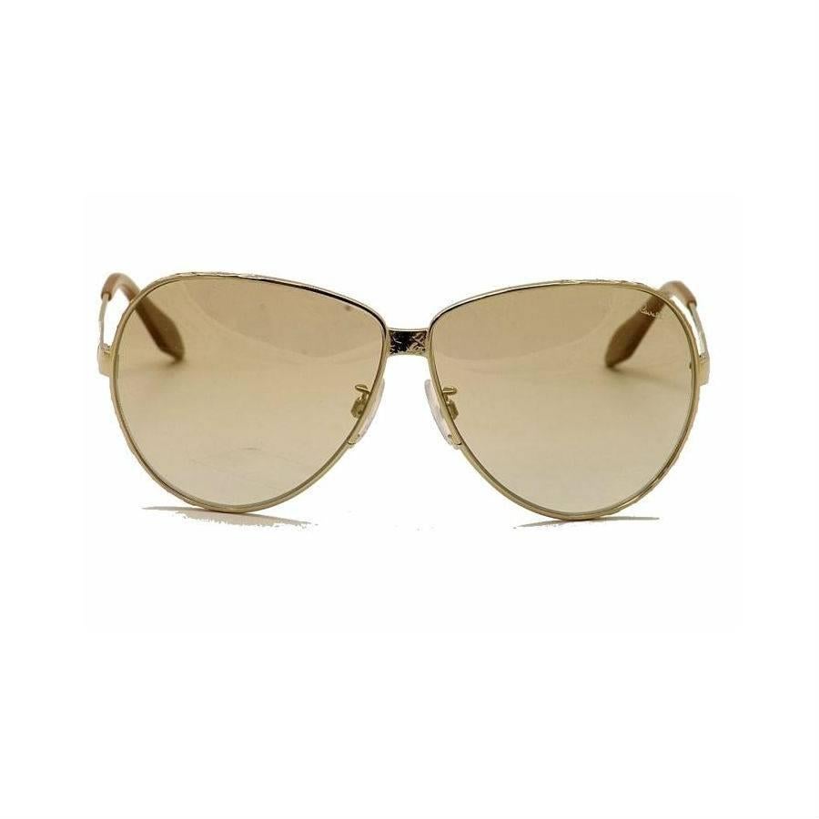 Roberto Cavalli Sunglasses, Gold

These Roberto Cavalli sunglasses feature an oversized metal aviator gold frame with textured engraving on the edge of the frame and on the temples. Simply Stylish!

Specifications:
Brand: Roberto