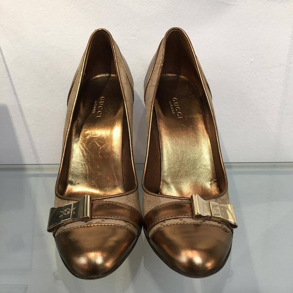 GUCCI GG monogram coated canvas heel pumps embellished with a gold tone bow and brown leather details.

Features:
o Authentic Gucci Guccissima beige high heel pumps
o Brand new never worn with box and dustbags
o Size: 7.5
o Indicative height