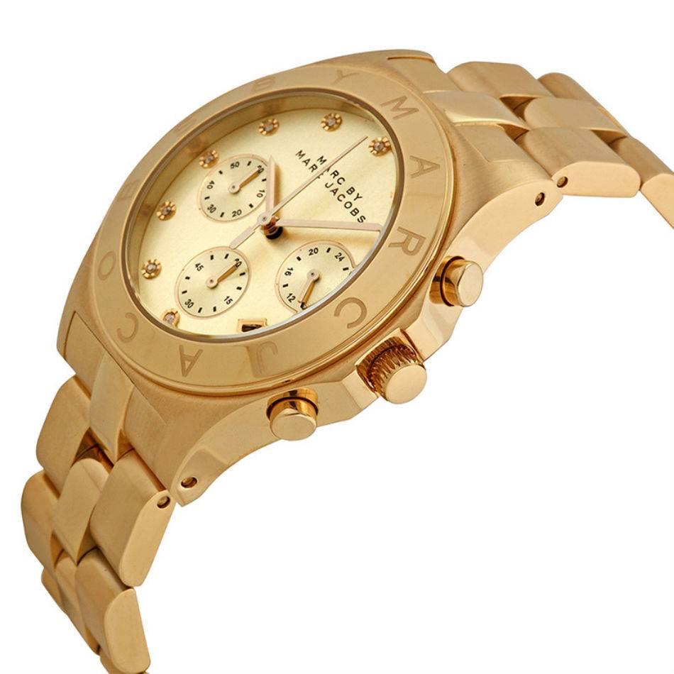 Gold-tone stainless steel case and bracelet. Fixed gold-tone bezel. Gold dial with gold-tone hands and Swarovski crystal hour markers. Dial Type: Analog. Date display appears between the 4 and 5 o'clock positions. Chronograph - three sub-dials